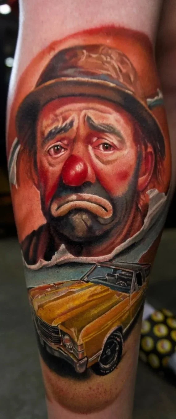 Color realism tattoo by HIP pairing an expressive clown portrait with a gold car and warm orange background