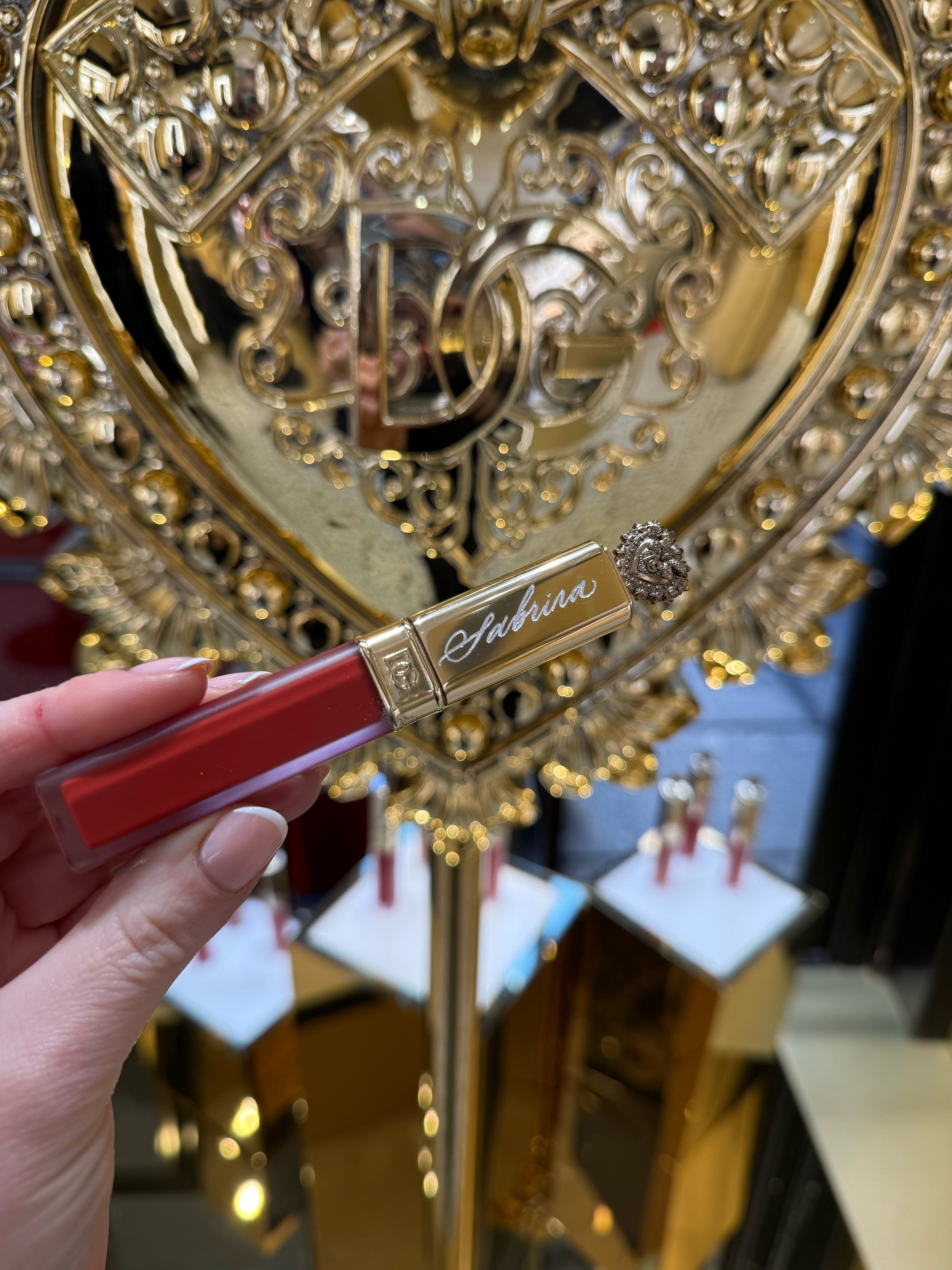 Hand engraved cosmetics for luxury brand activation in Dolce and Gabbana Covent Garden. Calligraphy engraving on lip gloss. Personalised cosmetics. Live calligraphy engraving london