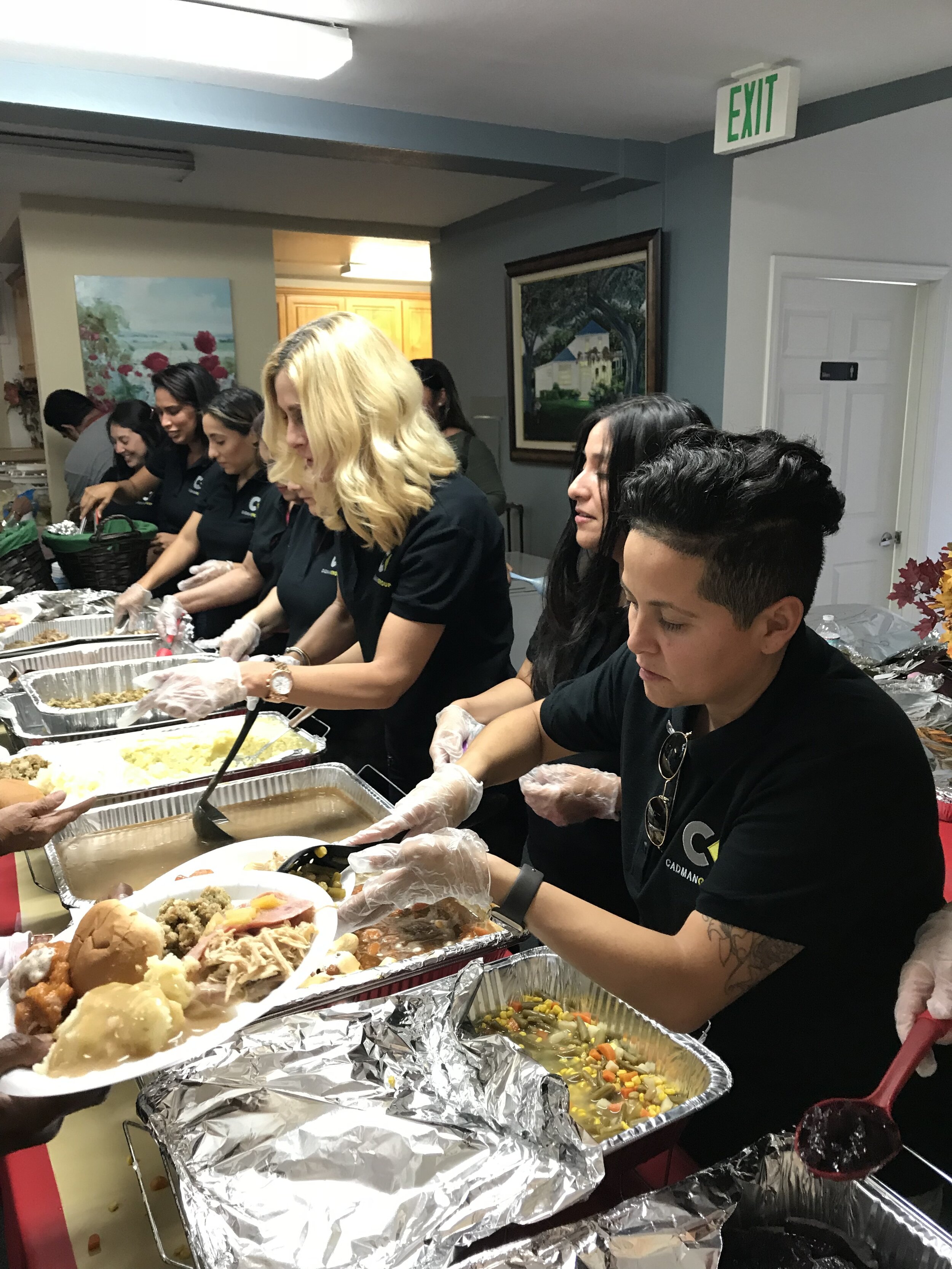 Cadman Group team members serving Thanksgiving dinner to tenant guests