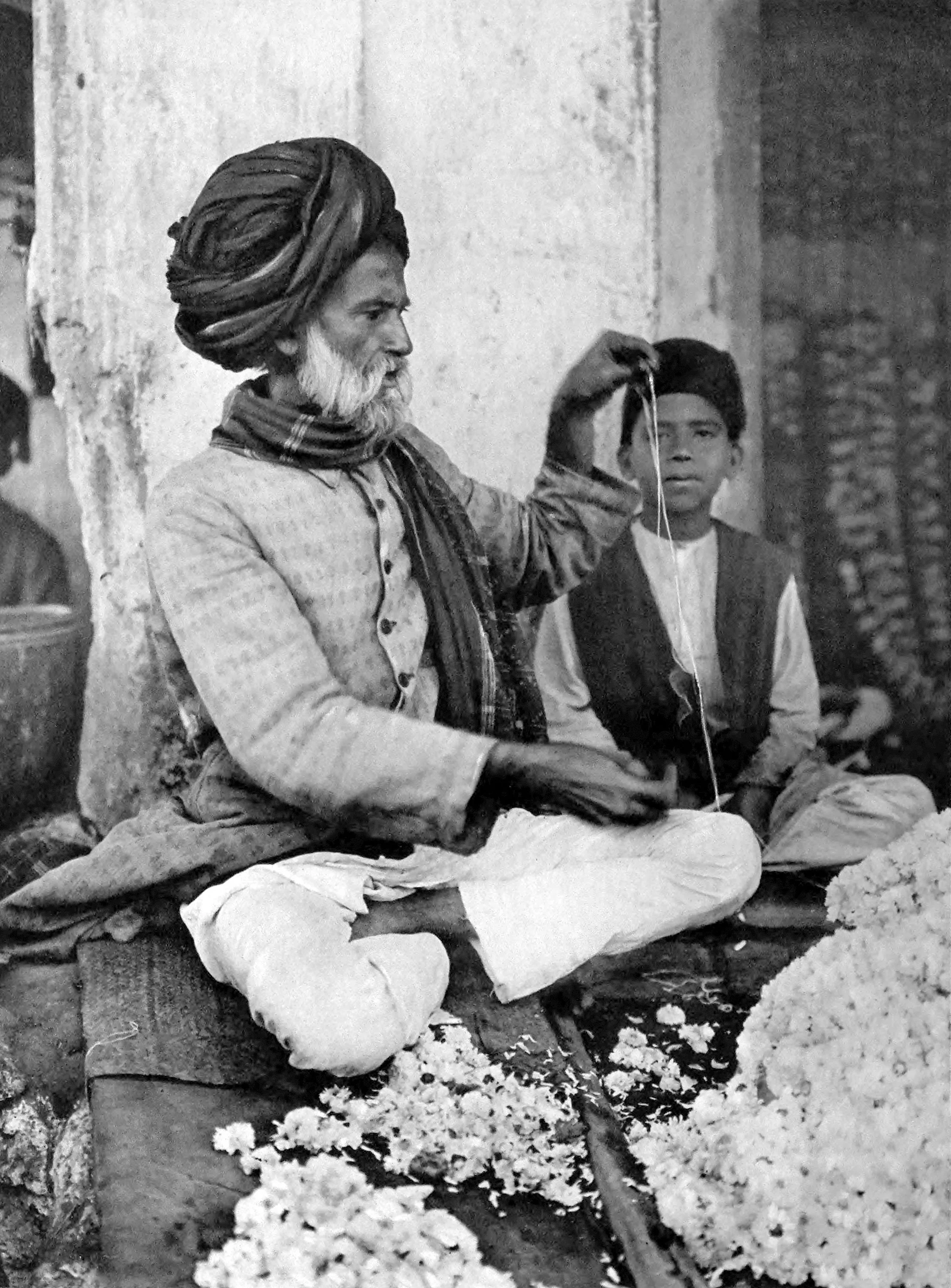 Hyderabad-Deccan. Flower seller putting together a garland