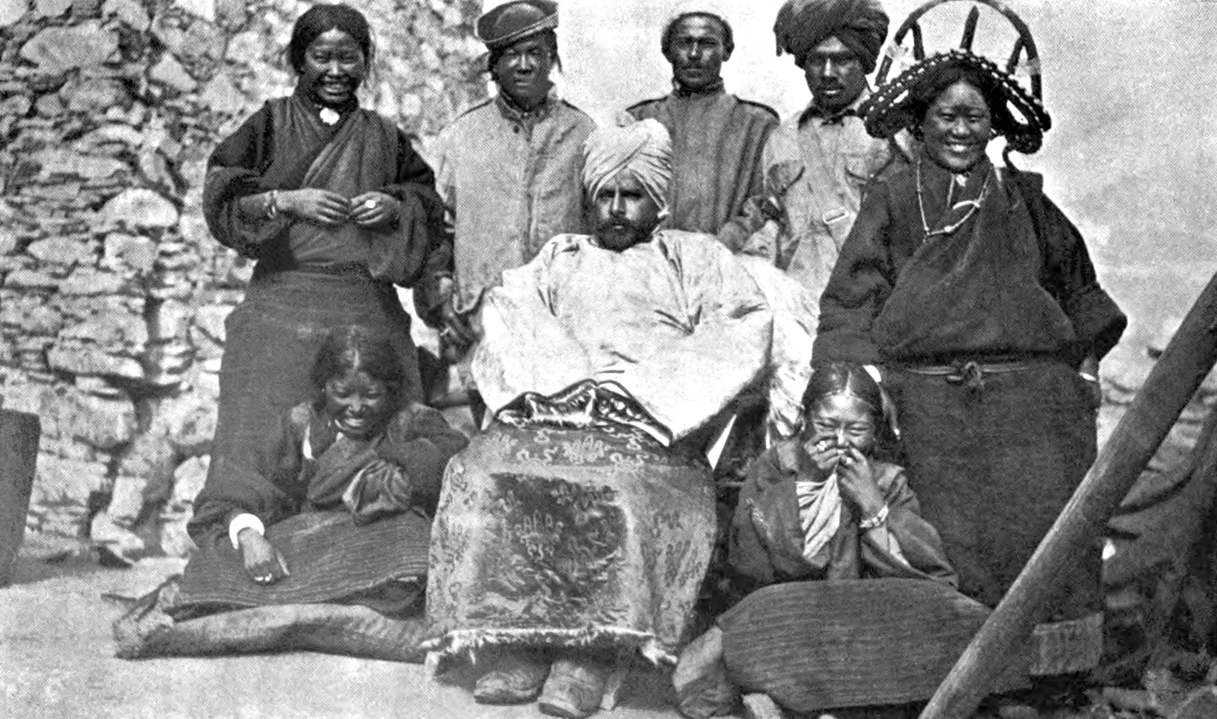 Indian official seated, behind him two Indian men and one Tibetan. Four Tibetan women.