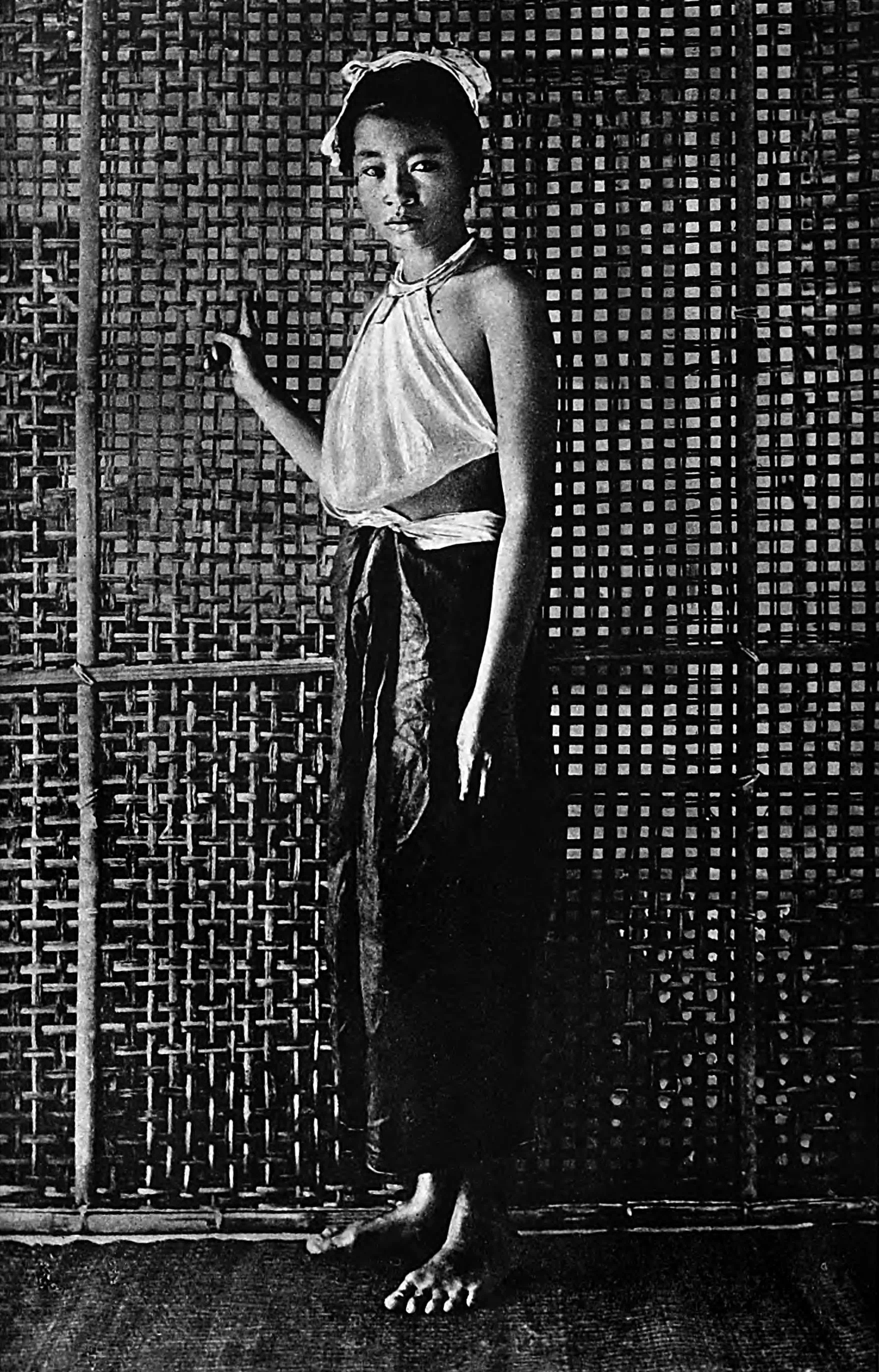 Indoors, Annamese women wear loose trousers and a small square fichu tied to neck and waist