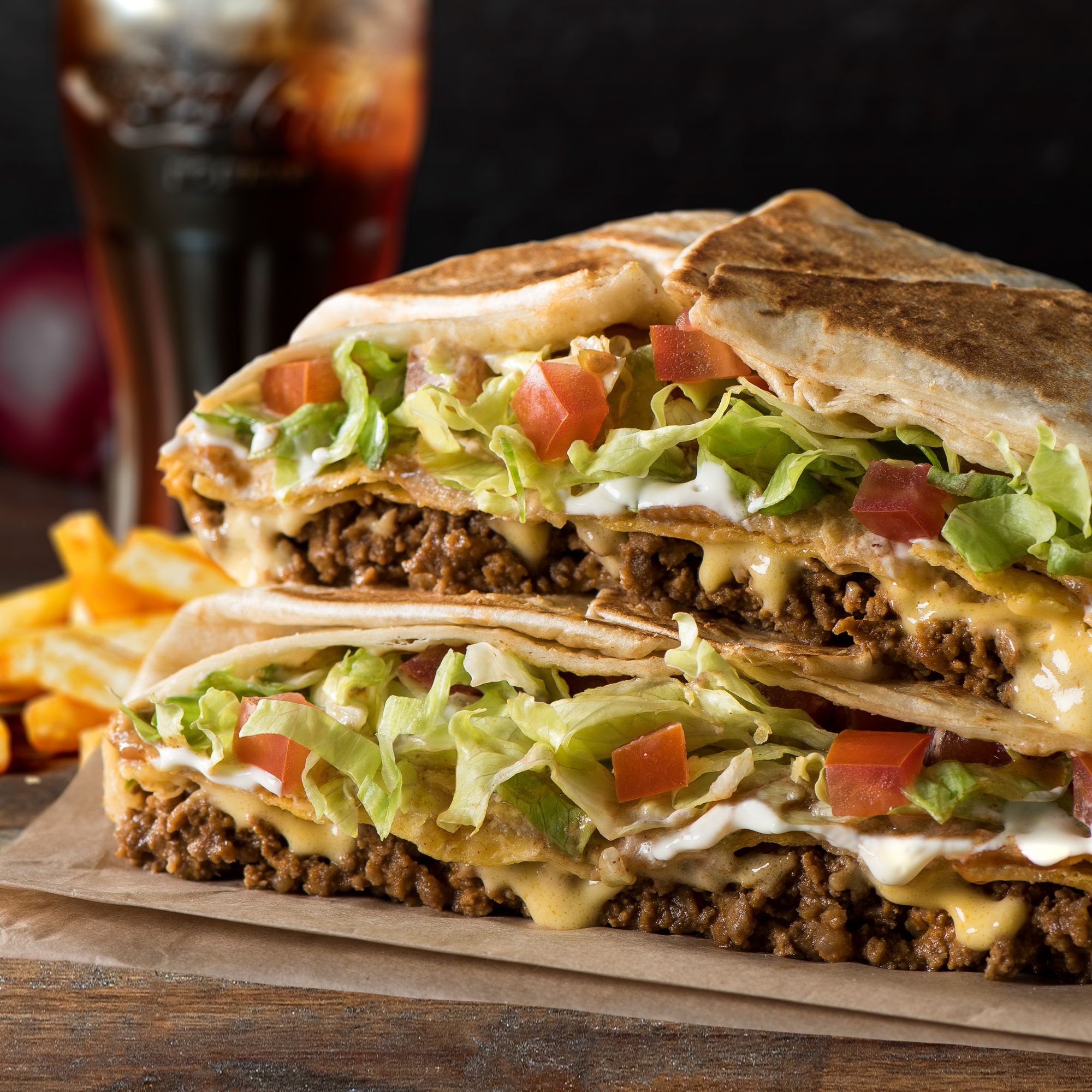 Crunchwrap Supreme™®  Your choice of protein, warm nacho cheese sauce, freshly fried crunchy tostada, sour cream, shredded iceberg lettuce and diced tomato inside our signature hexagonal form. Grilled to perfection!