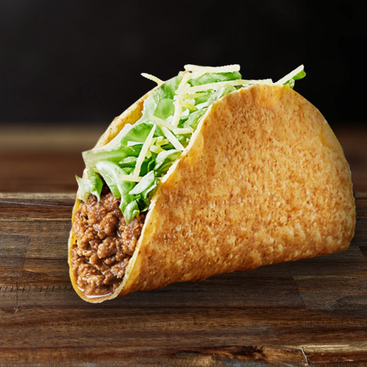 CRUNCHY TACO  Introduced into the world in 1962 by Taco Bell’s founder, Glen Bell, our crunchy taco shells are fried fresh in our kitchens daily. This staple menu item is filled with Taco Bell’s famous seasoned beef, shredded iceberg lettuce and topped with cheddar cheese.