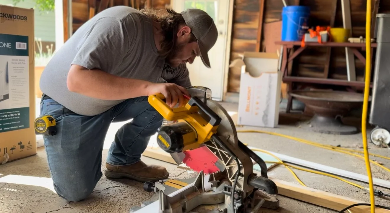Jay operating a miter saw to cut trim for a bathroom remodel.