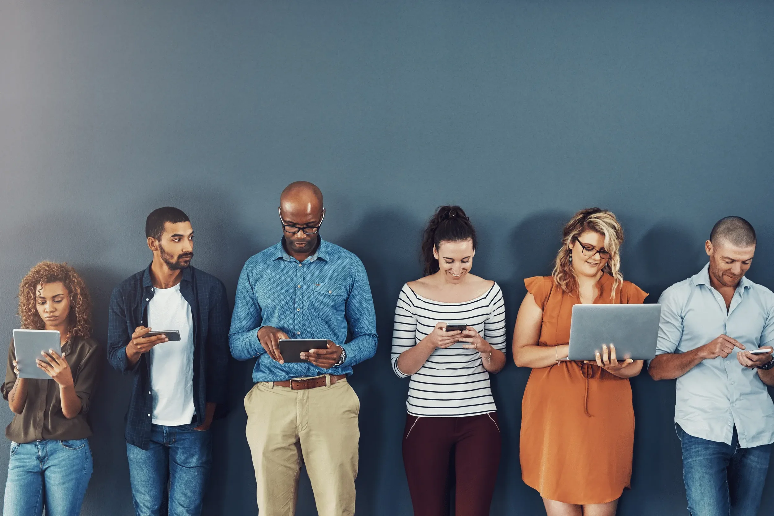 Diverse group of professionals engaging with digital devices, representing LinkedIn thought leadership and social media strategy for B2B marketing