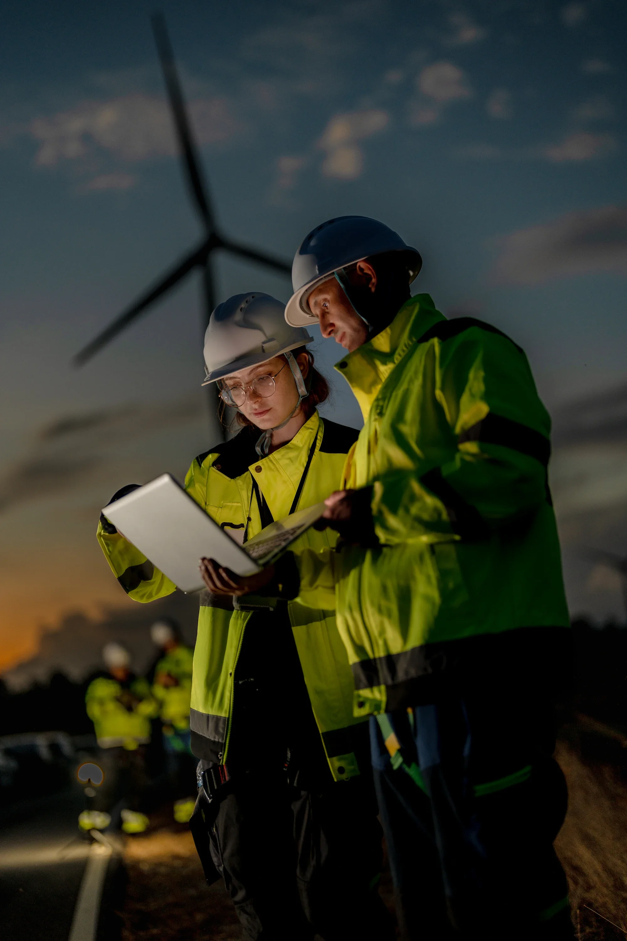 Renewable Energy Engineers Reviewing Site Data at Dusk