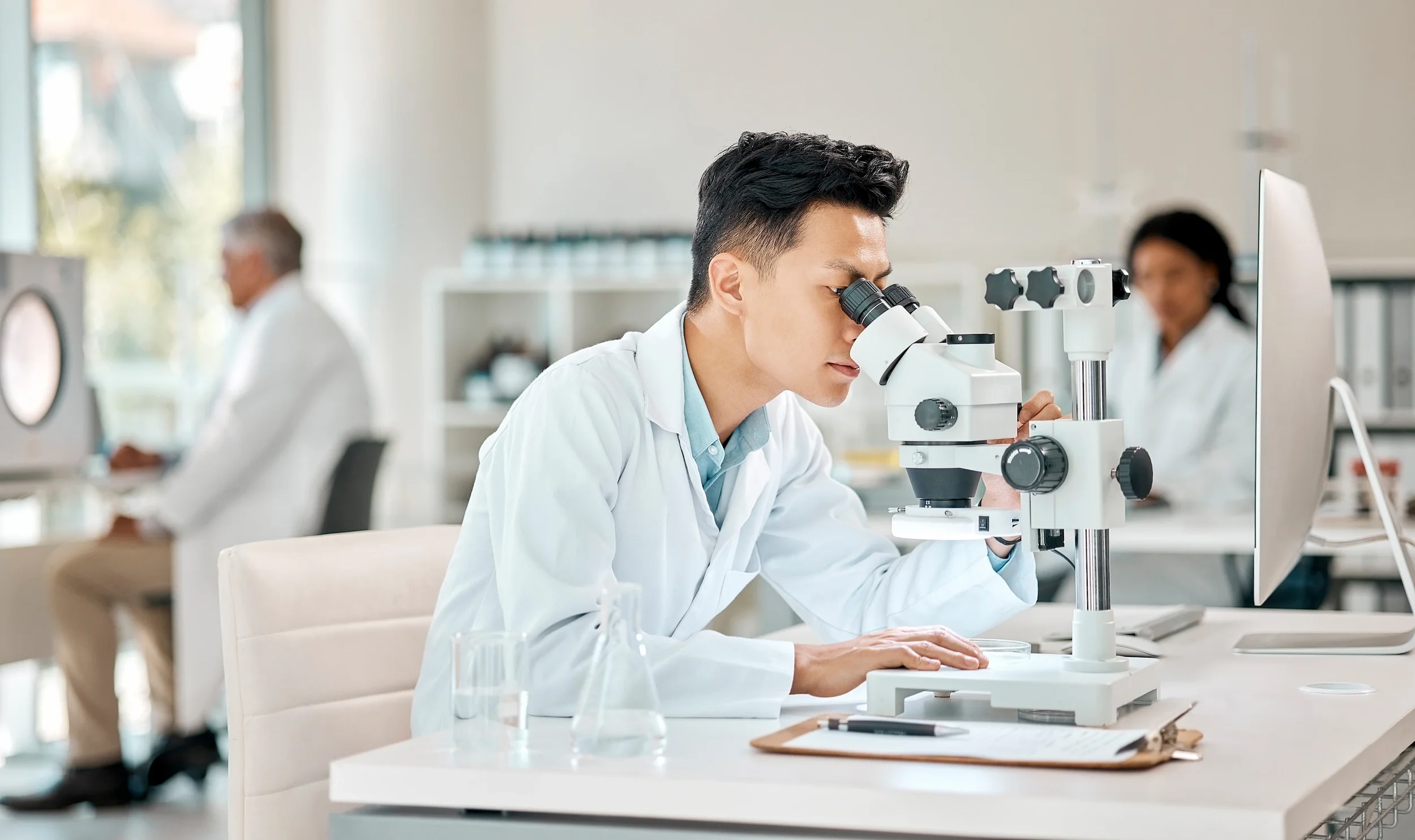 Scientist examining a sample through a laboratory microscope