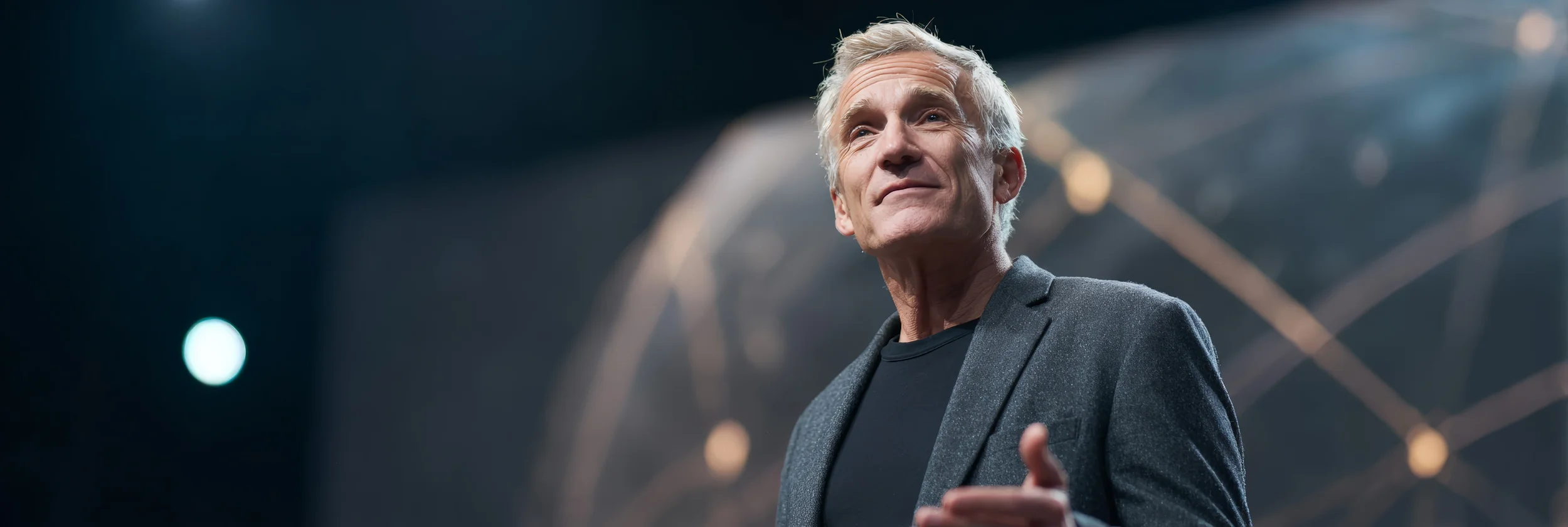 Board‑level leader of global strategy and design consultancy speaking on stage with network backdrop, illustrating authority growth in Beauxhaus integrated marketing case study