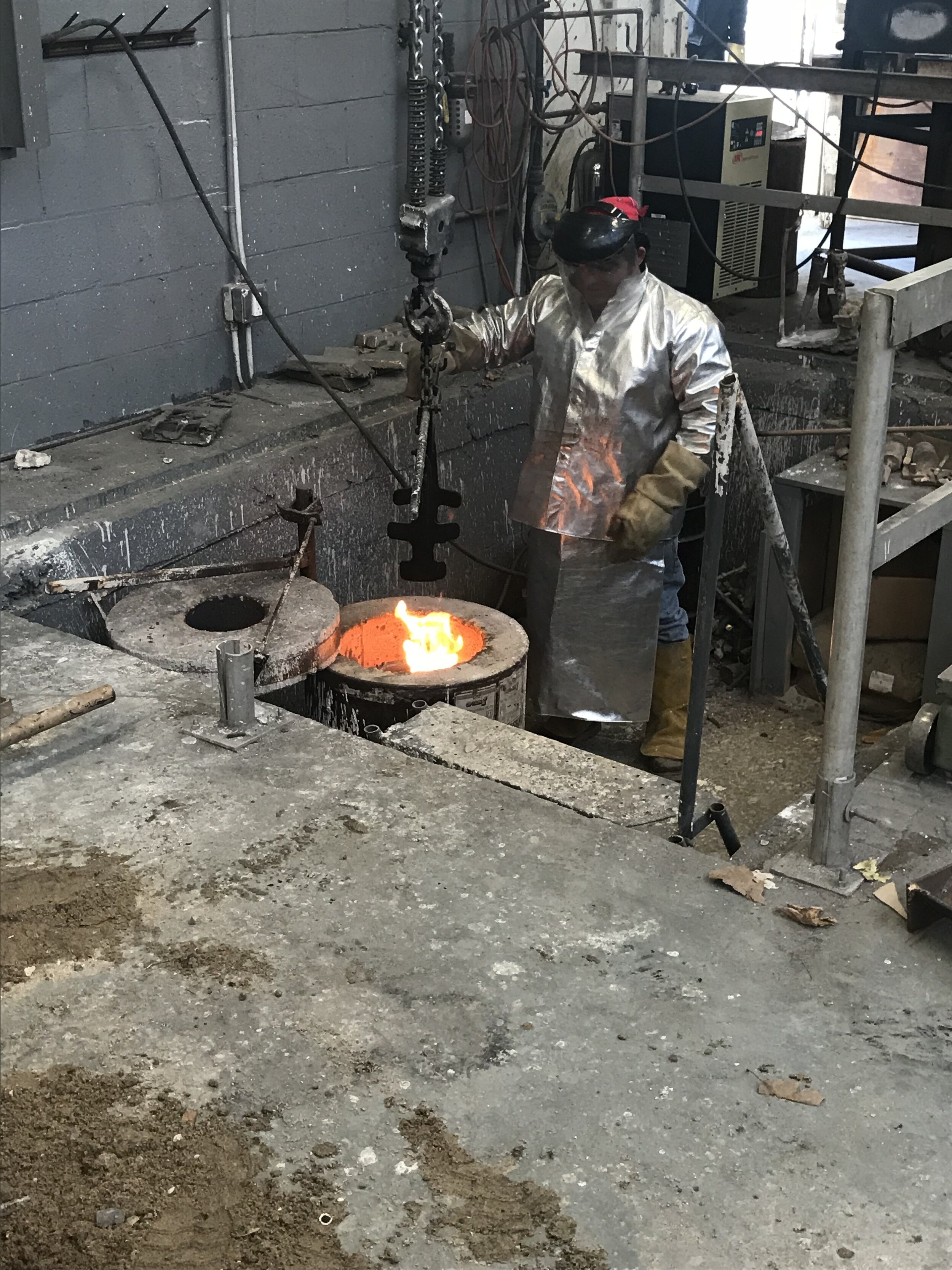  artist pulling the molten bronze out of the furnace 