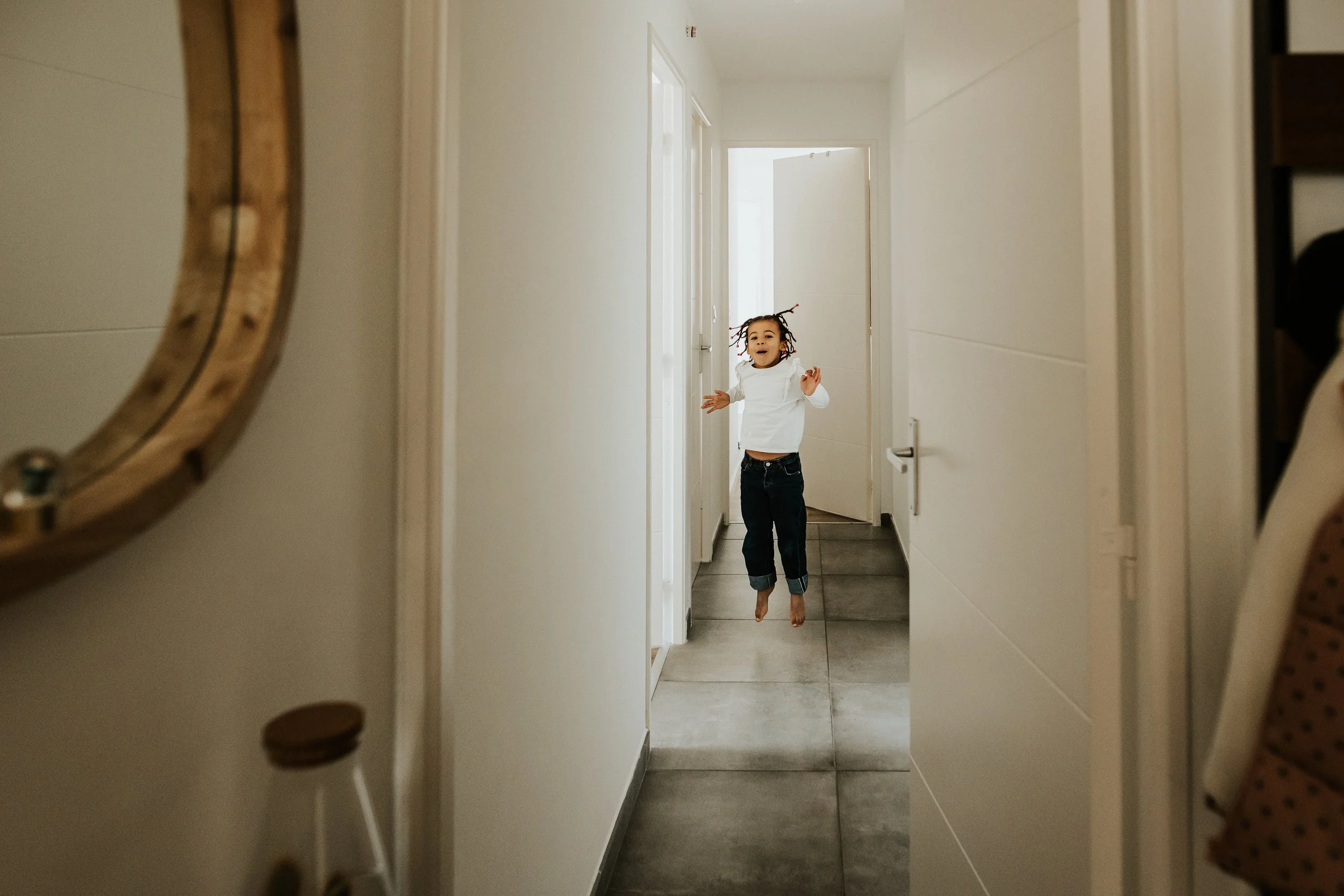 photo d'une petite fille sautant dans le couloir de leur domicile à Villeurbanne