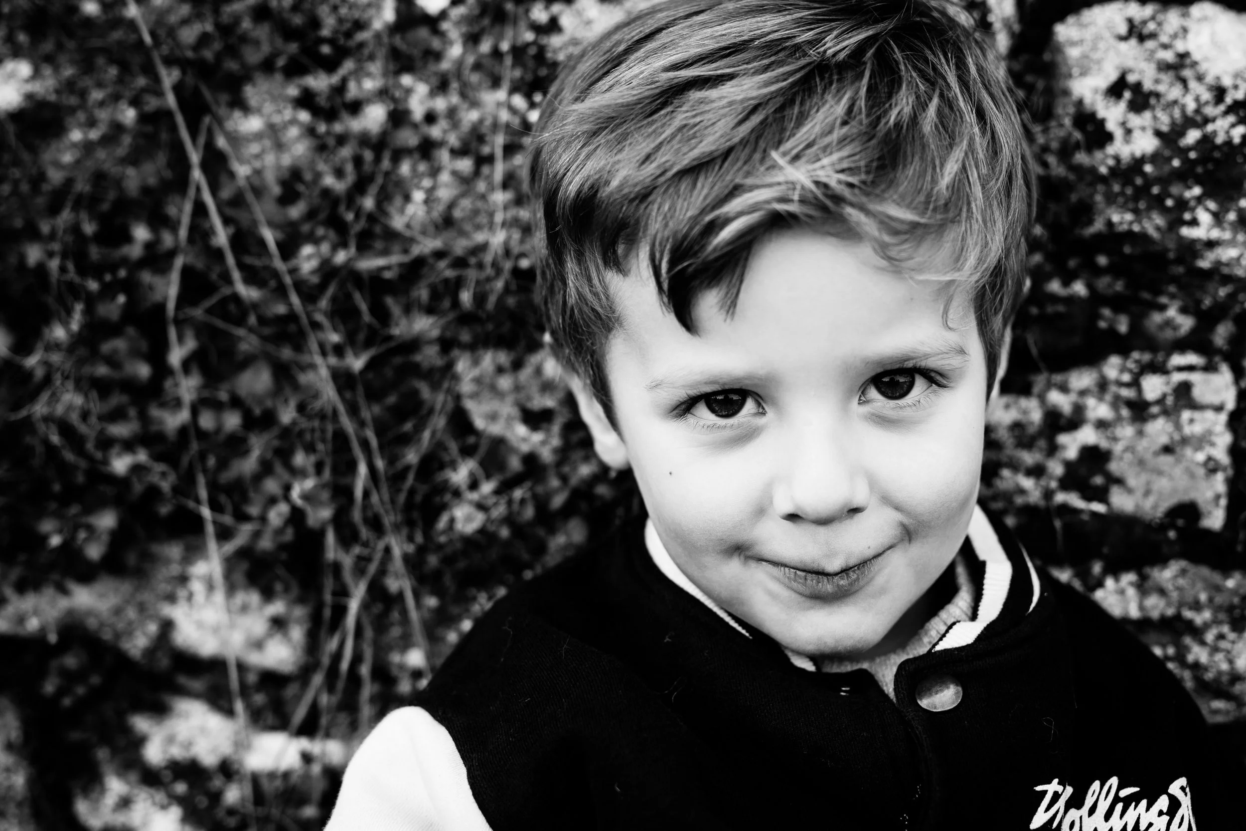 portrait d'un enfant en noir et blanc pendant une séance photo en famille offerte à ses grand-parents dans le Beaujolais