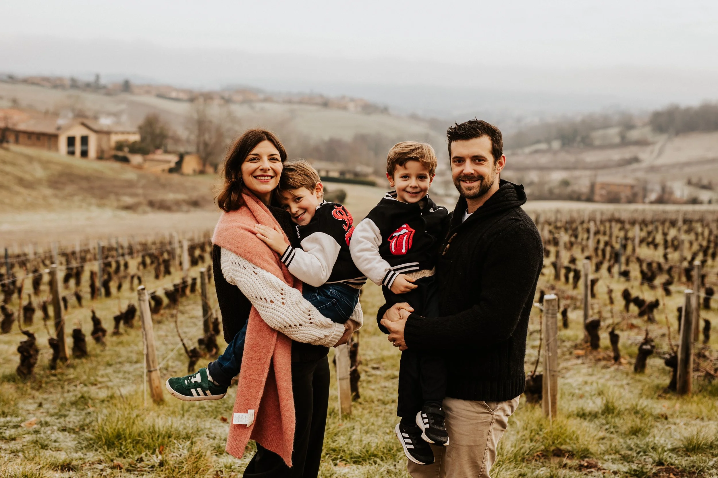 photo d'une famille heureuse malgré le froid dans les vignes du beaujolais près de villefranche_sur_saone