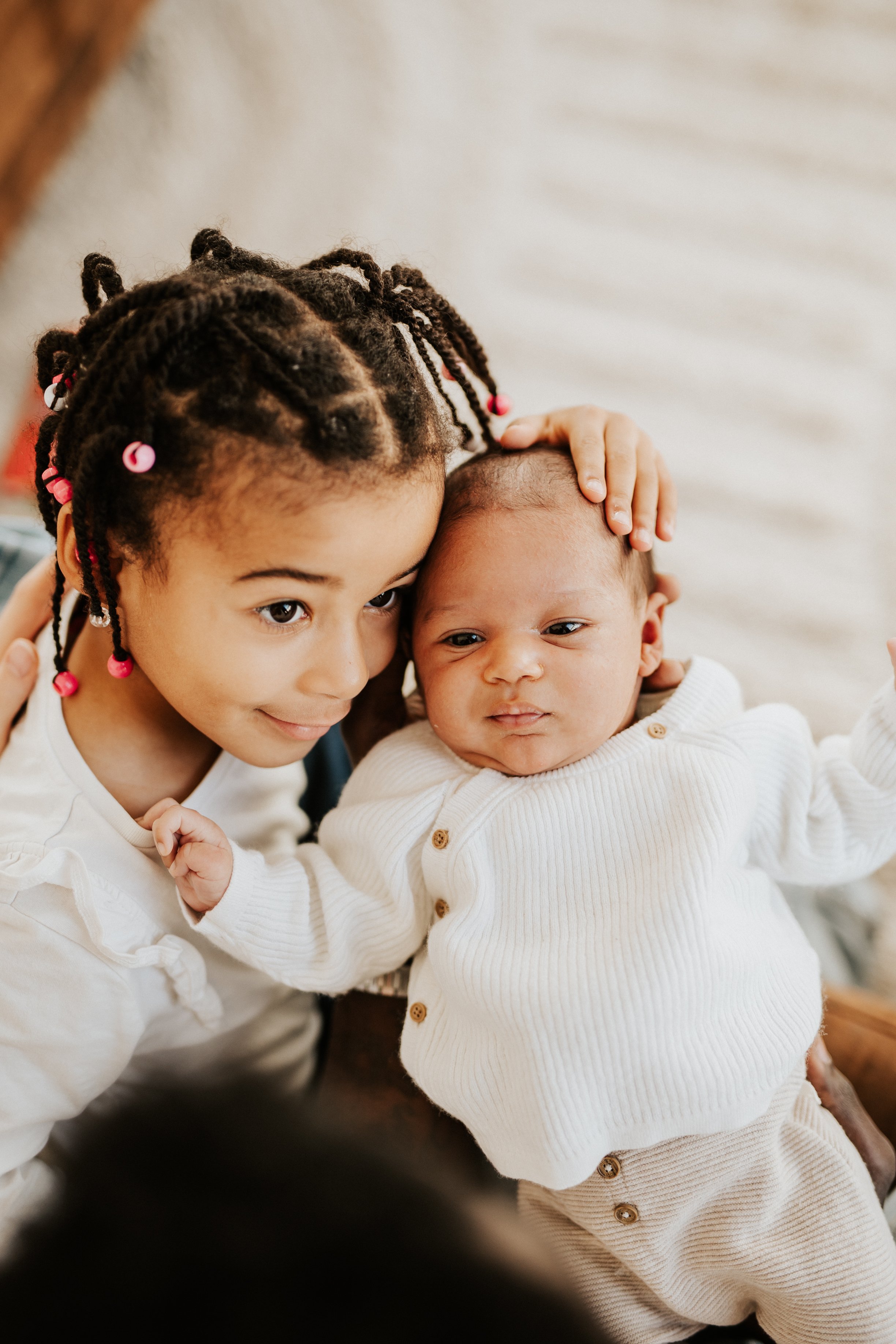 photo pleine d'amour d'un bébé et sa magnifique grande soeur métisse