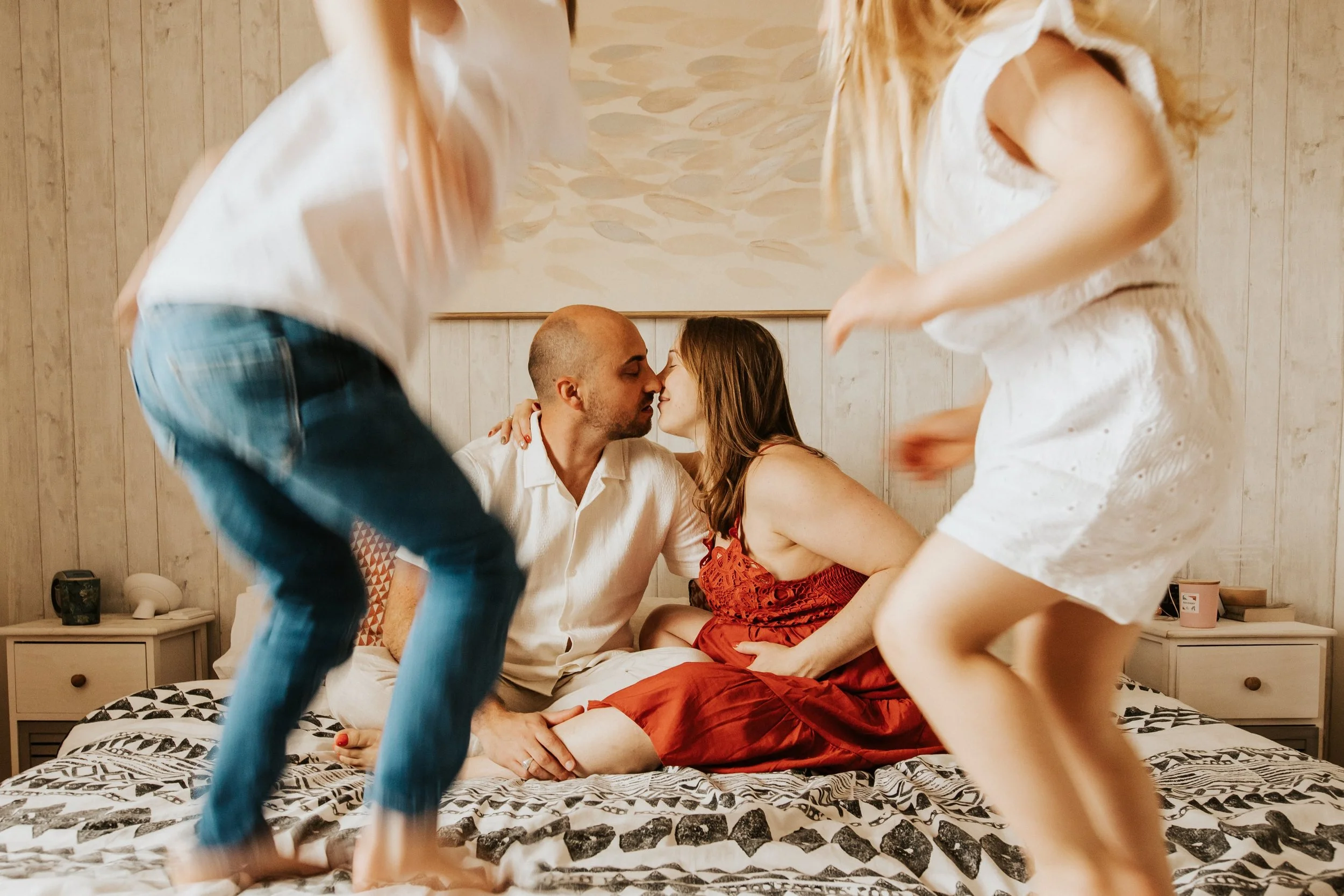photo d'un moment de jeu et de vie sur le lit de leur parents pendant la séance grossesse à domicile près de Lyon