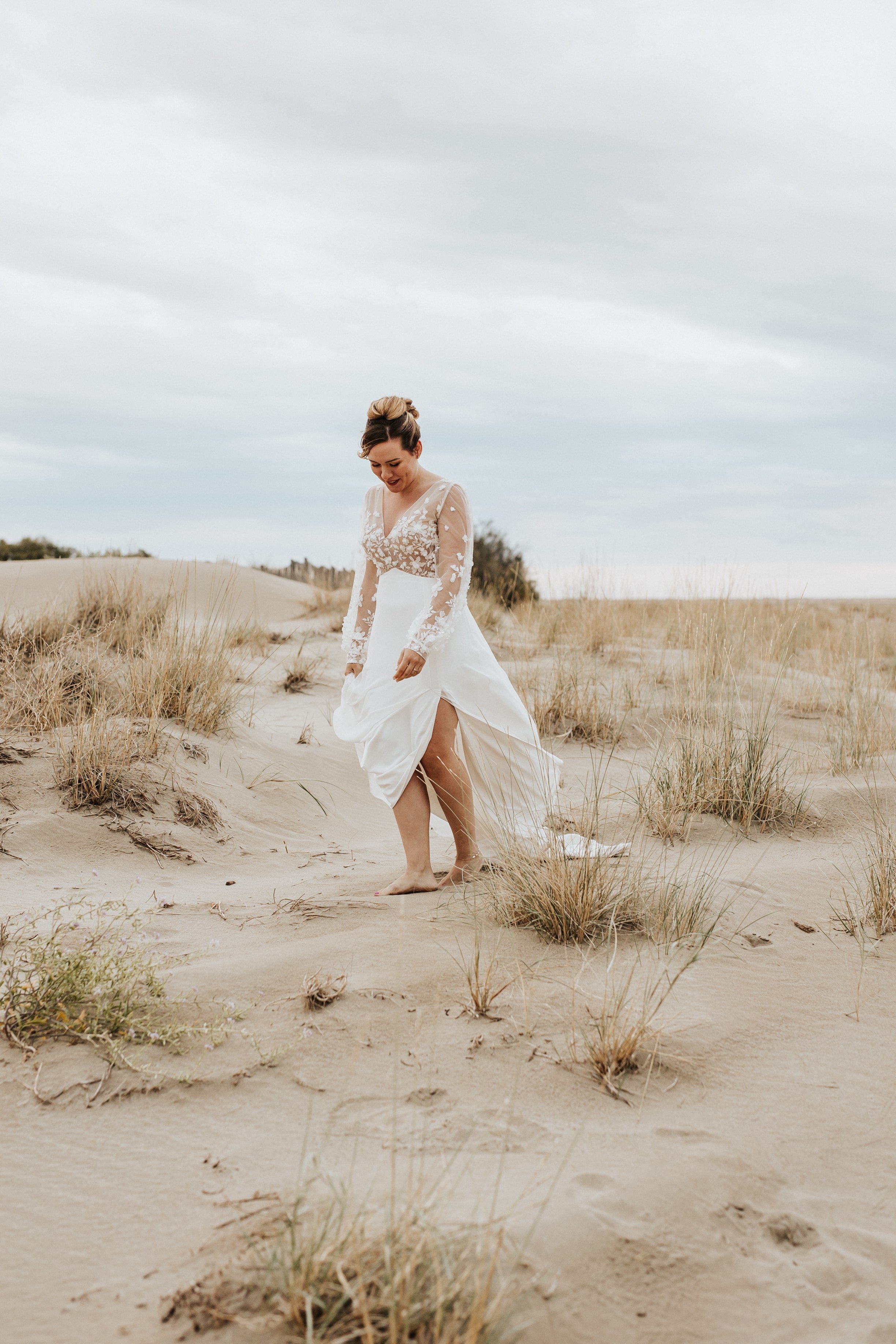 mariée marchant dans les dunes de sables pendans sa séance après son mariage près de montpellier