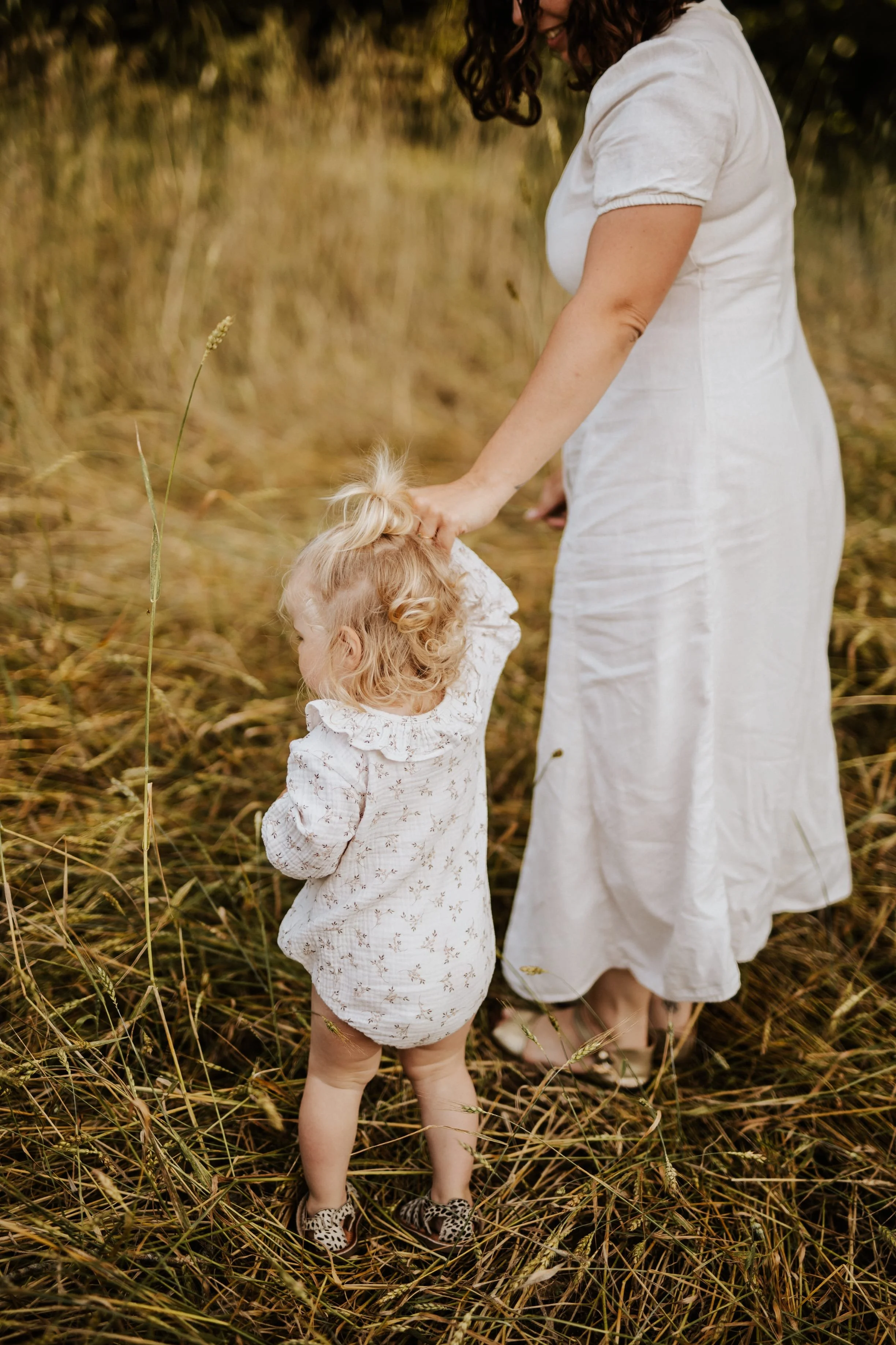 photo de maman et bébé main dans la main dans un champs de blé en début d'été près de Lyon