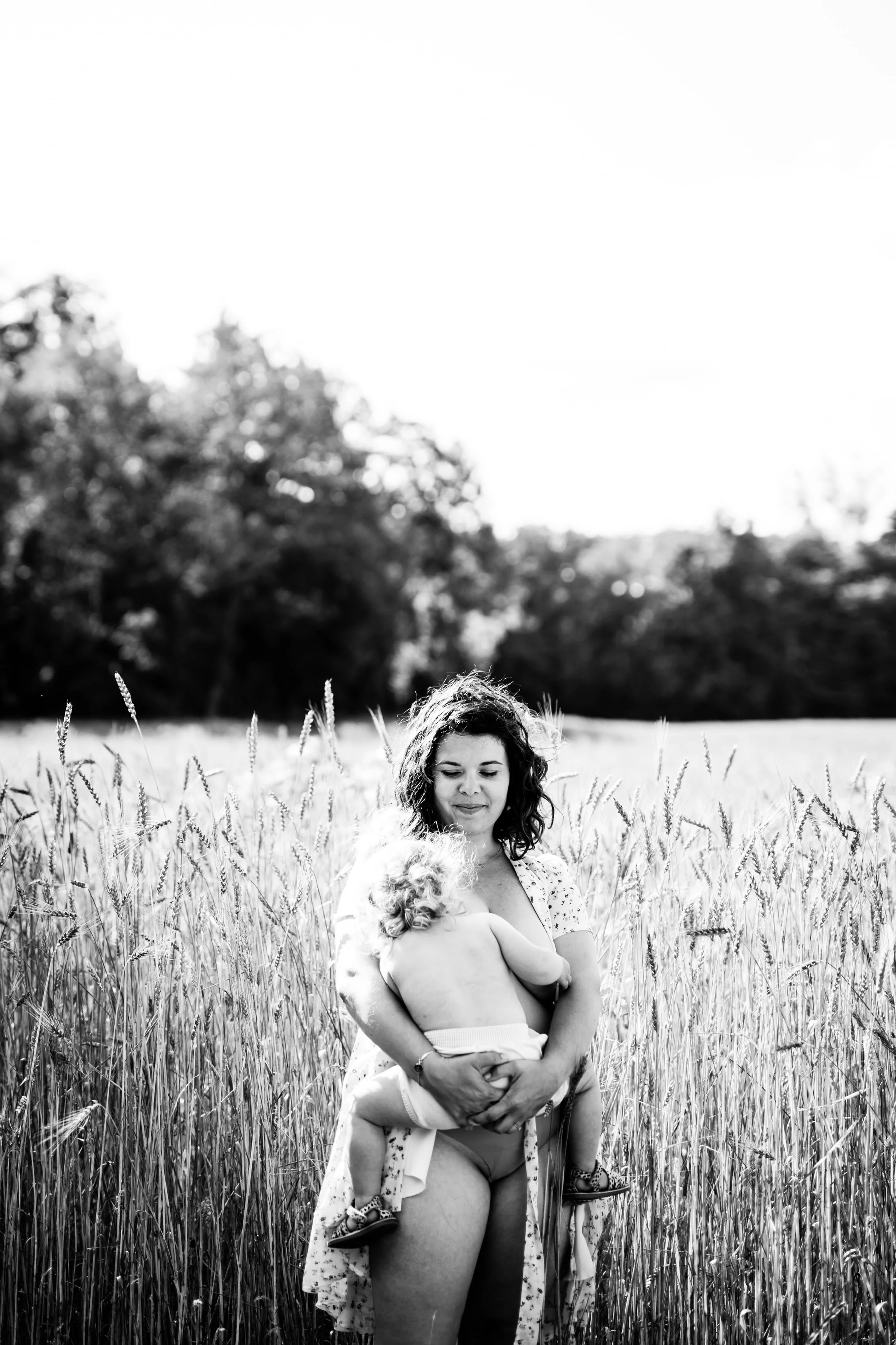 photo de maman calinant bébé en noir et blanc dans la nature près de lyon
