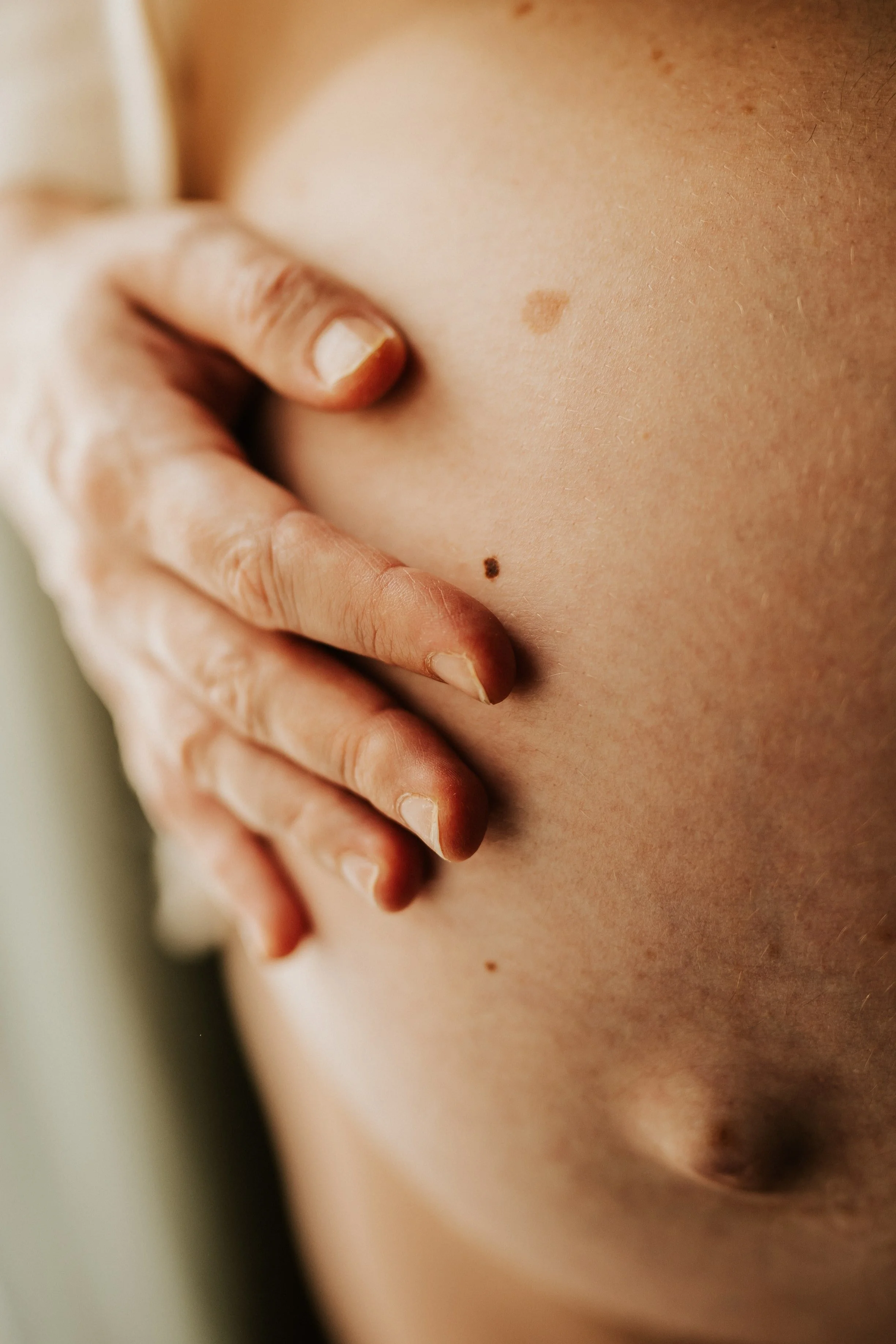 photo de détail du ventre d'une future maman pendant sa séance grossesse à domicile
