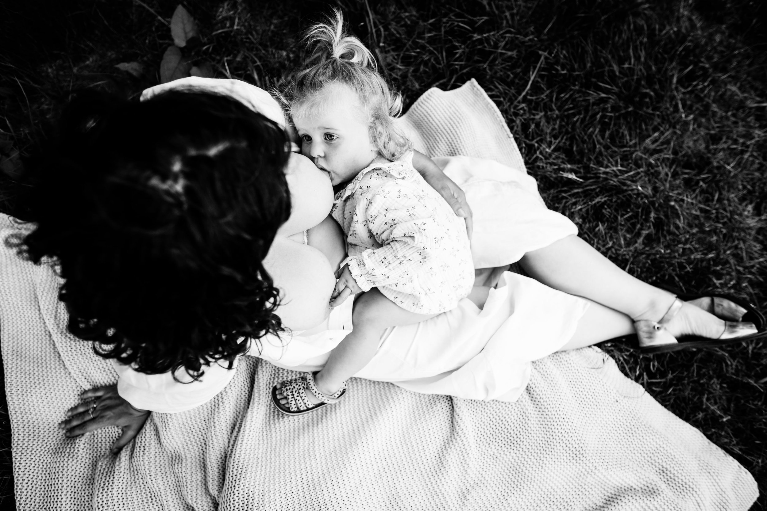 photo noir et blanc d'un moment allaitement en pleine nature dans l'herbe près de Lyon