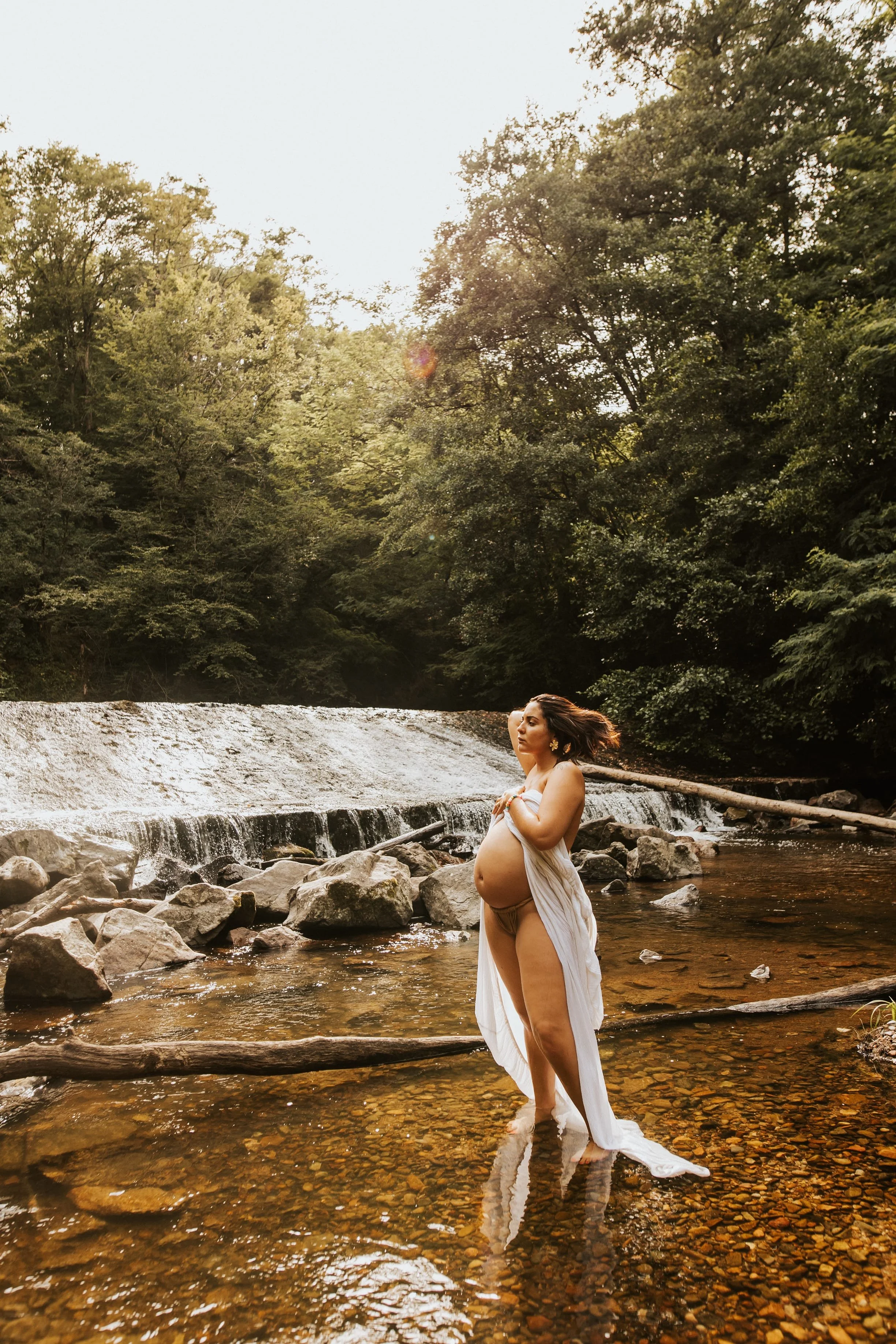 photo d'une future maman dénudée dans une rivière pendant sa séance photos grossesse intimiste près de villefranche sur saone