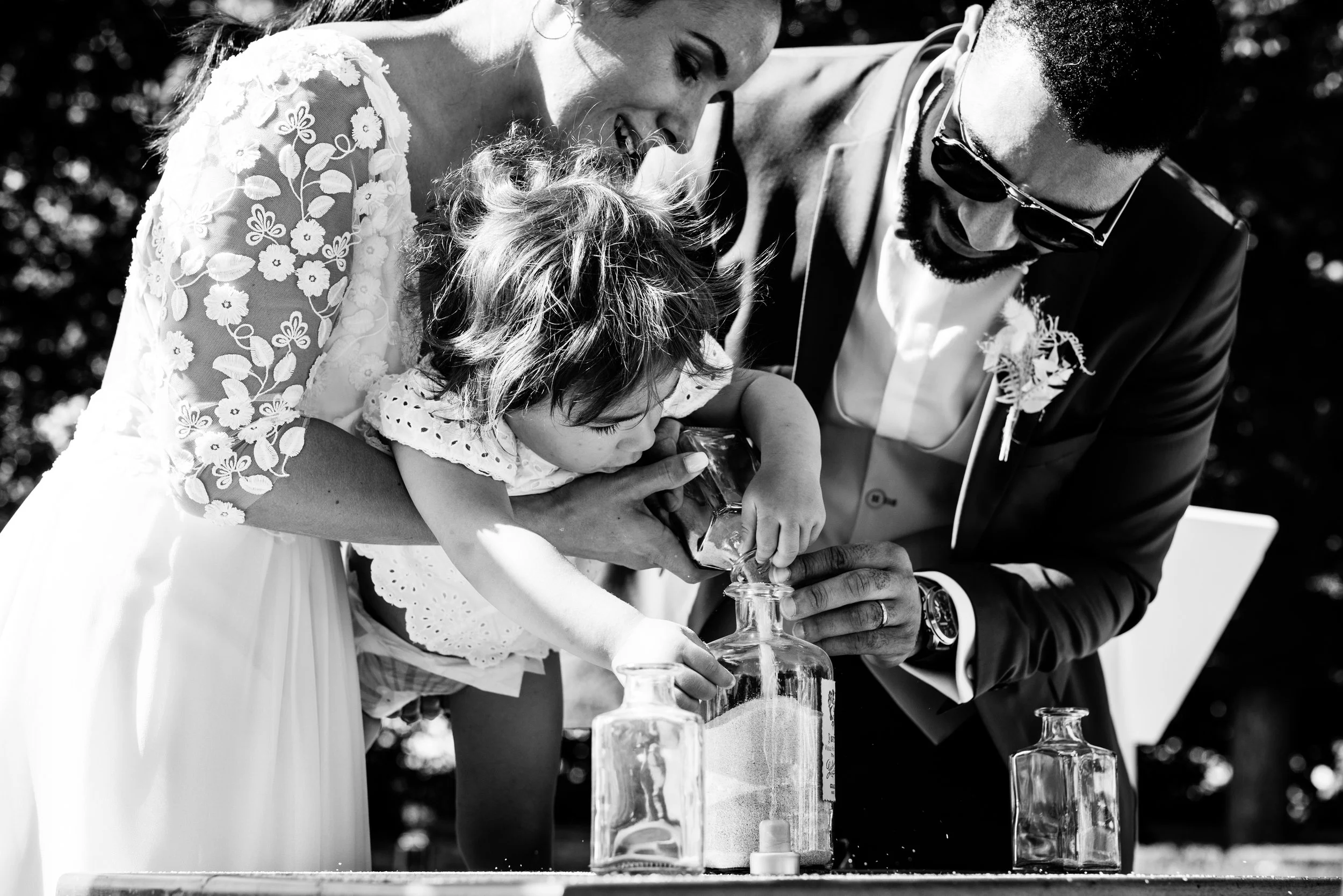 photo en noir et blanc d'un rituel du sable avec enfant lors d'une cérémonie laïque d'un mariage près de Lyon