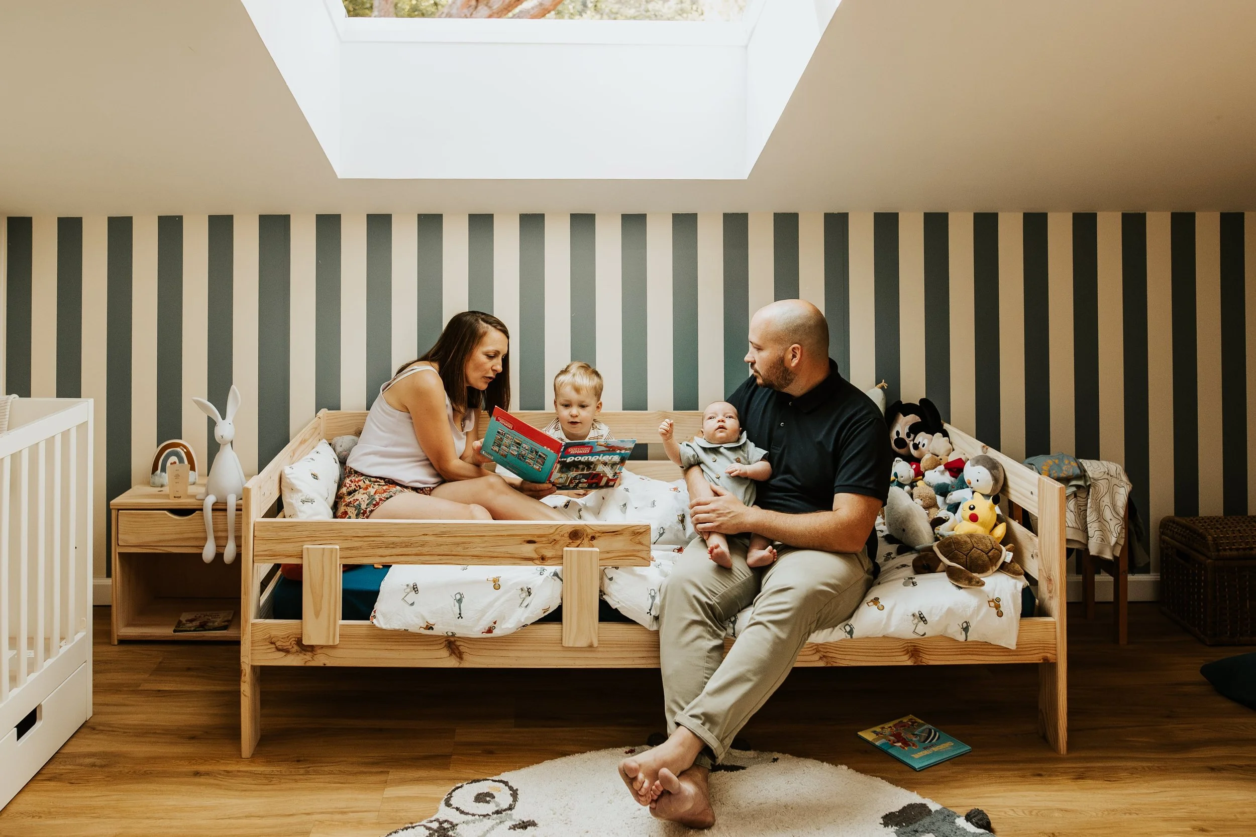photo d'une famille pendant un temps lecture lors de la séance photo de naissance à domicile dans le beaujolais près de Villefranche-sur-saone