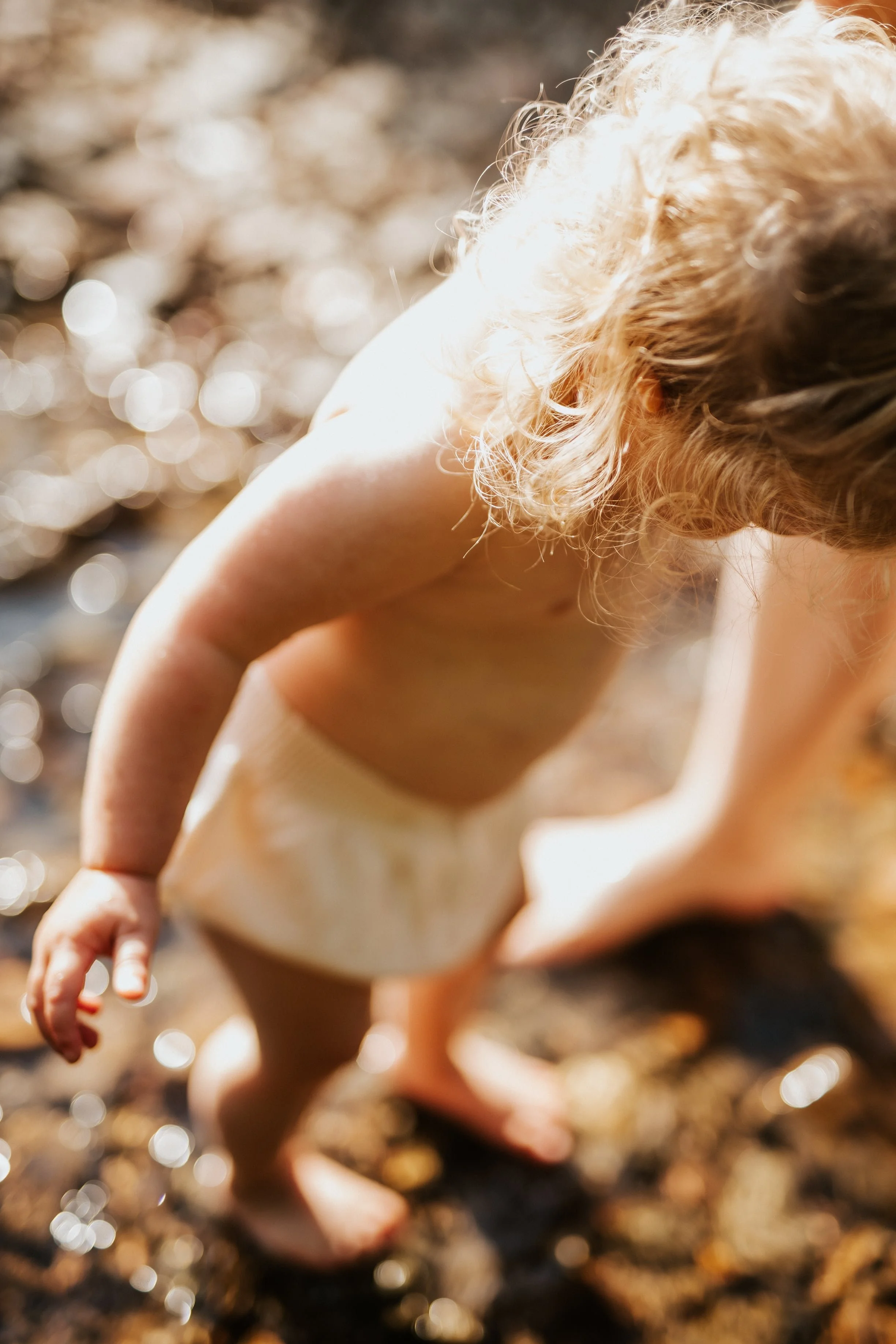 photo de détails de bébé trempant ses bien dans l'eau pendant une séance photo allaitement en pleine nature près de lyon