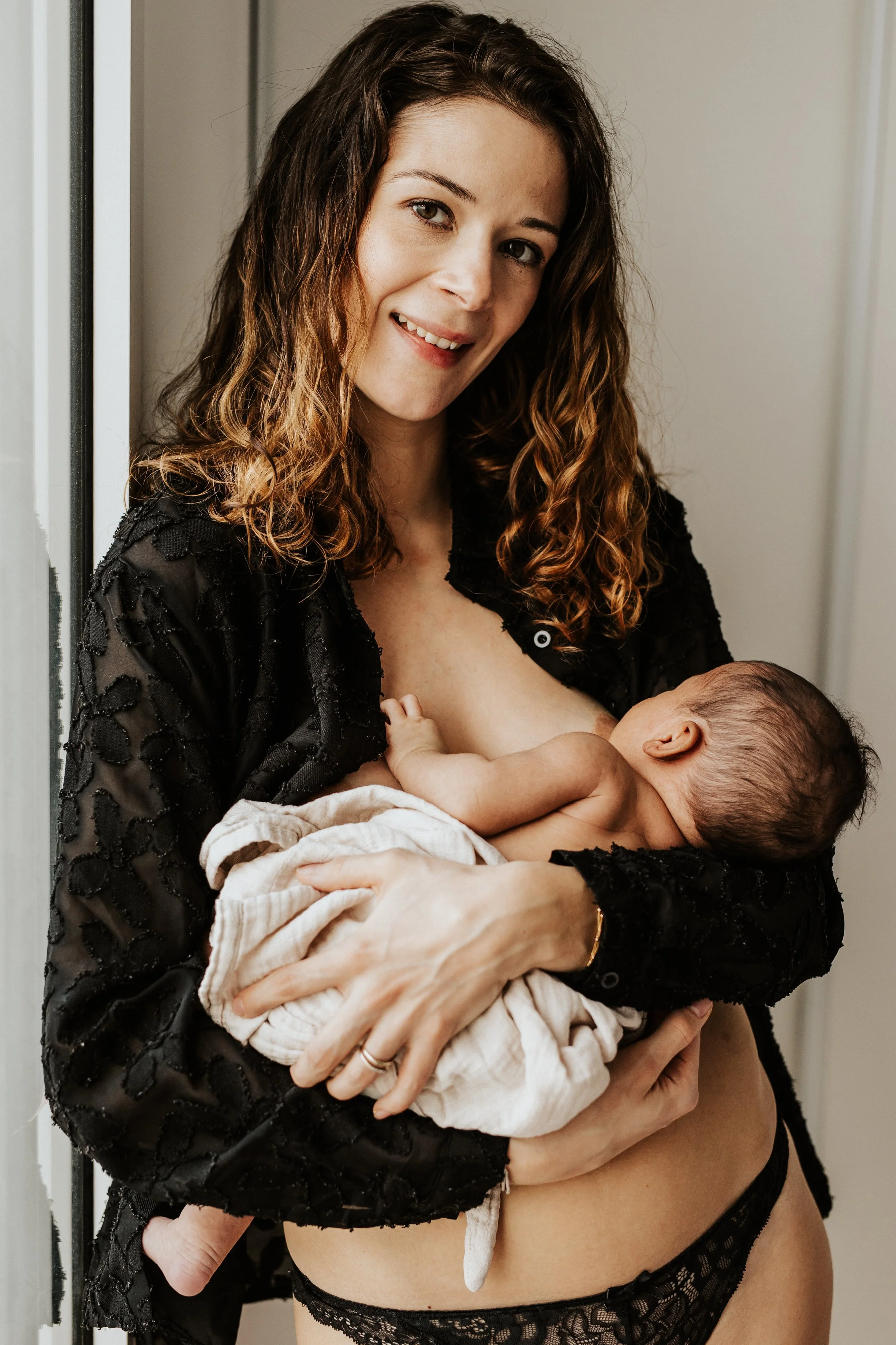 photo d'une magnifique future maman pendant son allaitement maternel, moment de "maternité intimiste" pendant la séance naissance à domicile près de Lyon