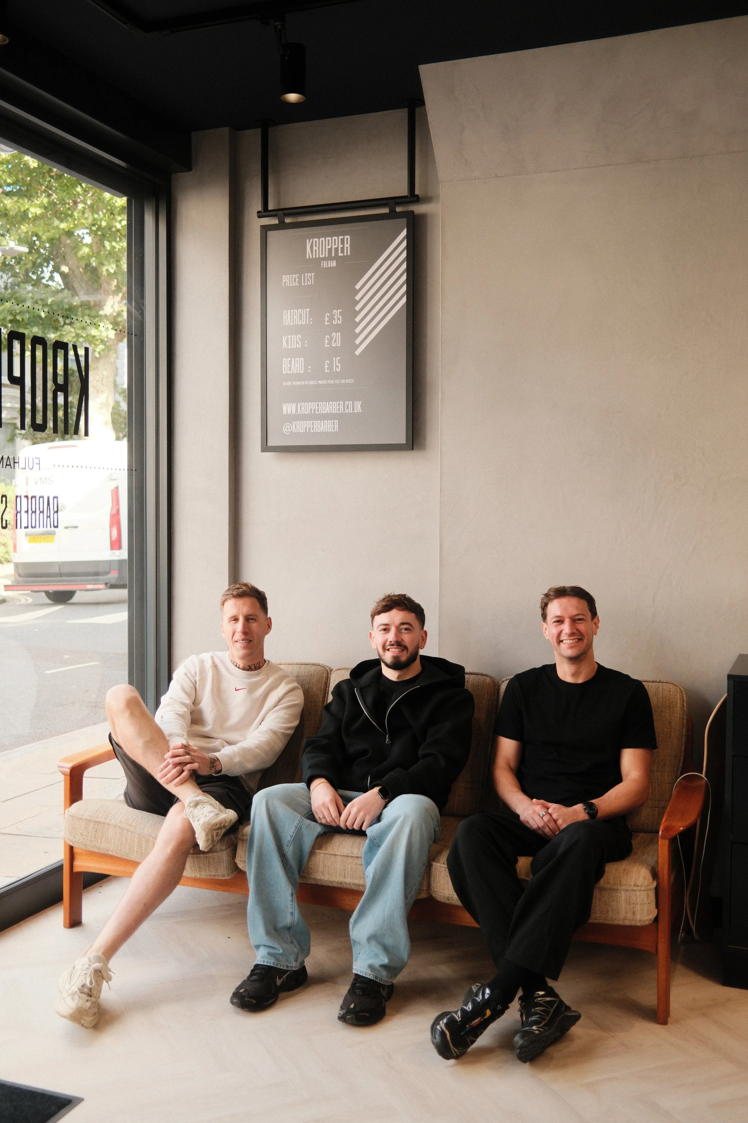 Kropper barbers at fulham broadway barbers. 3 barbers sit on a couch at fulham barbers