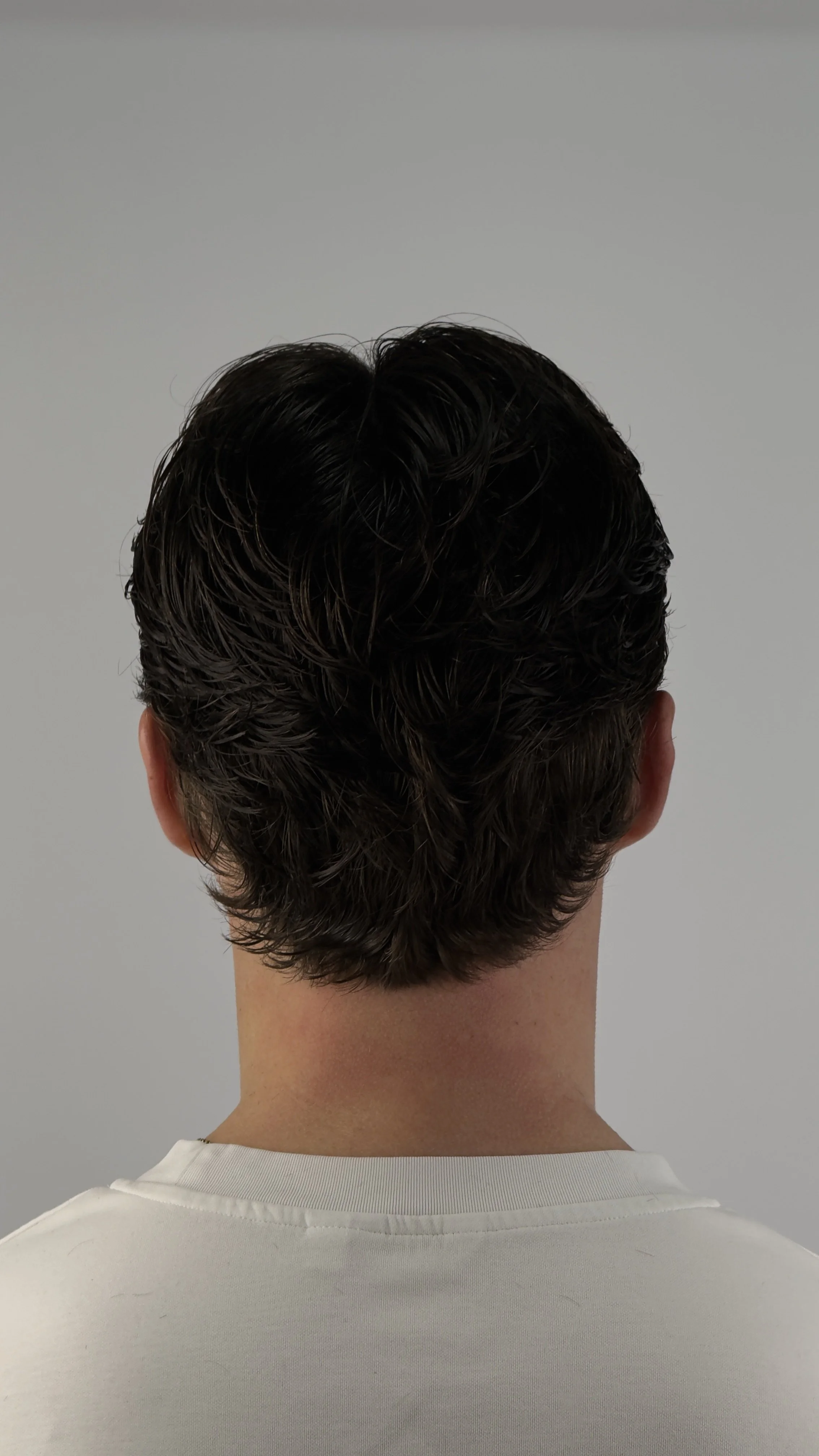 the flow haircut. back of a mens head with a long textured wild haircut popularly know as the flow