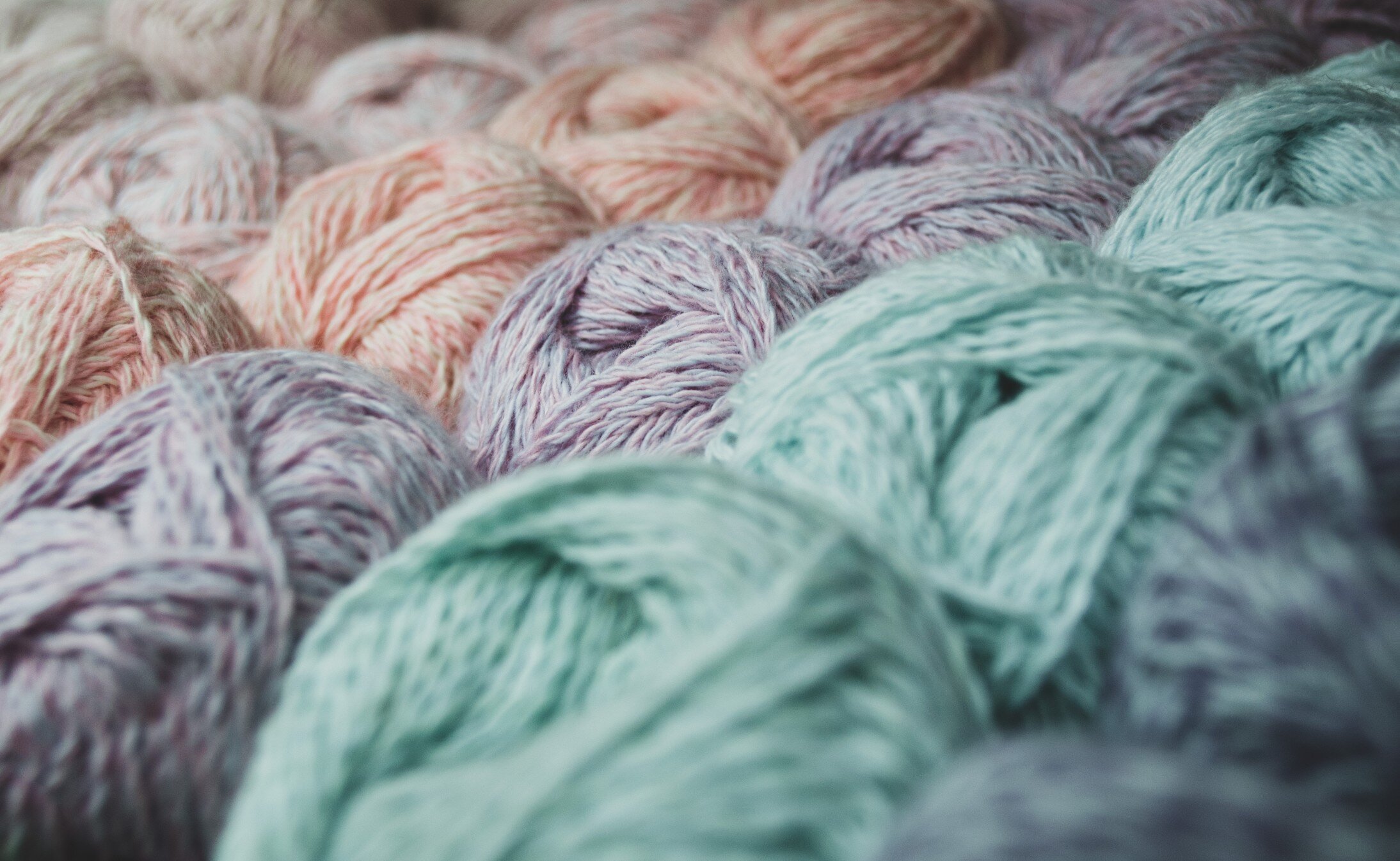 close-up-of-skeins-of-lilac-pink-thread-around-blurred-skeins-of-pastel-colors-of-green-and-blue_t20_O0wwob.jpg