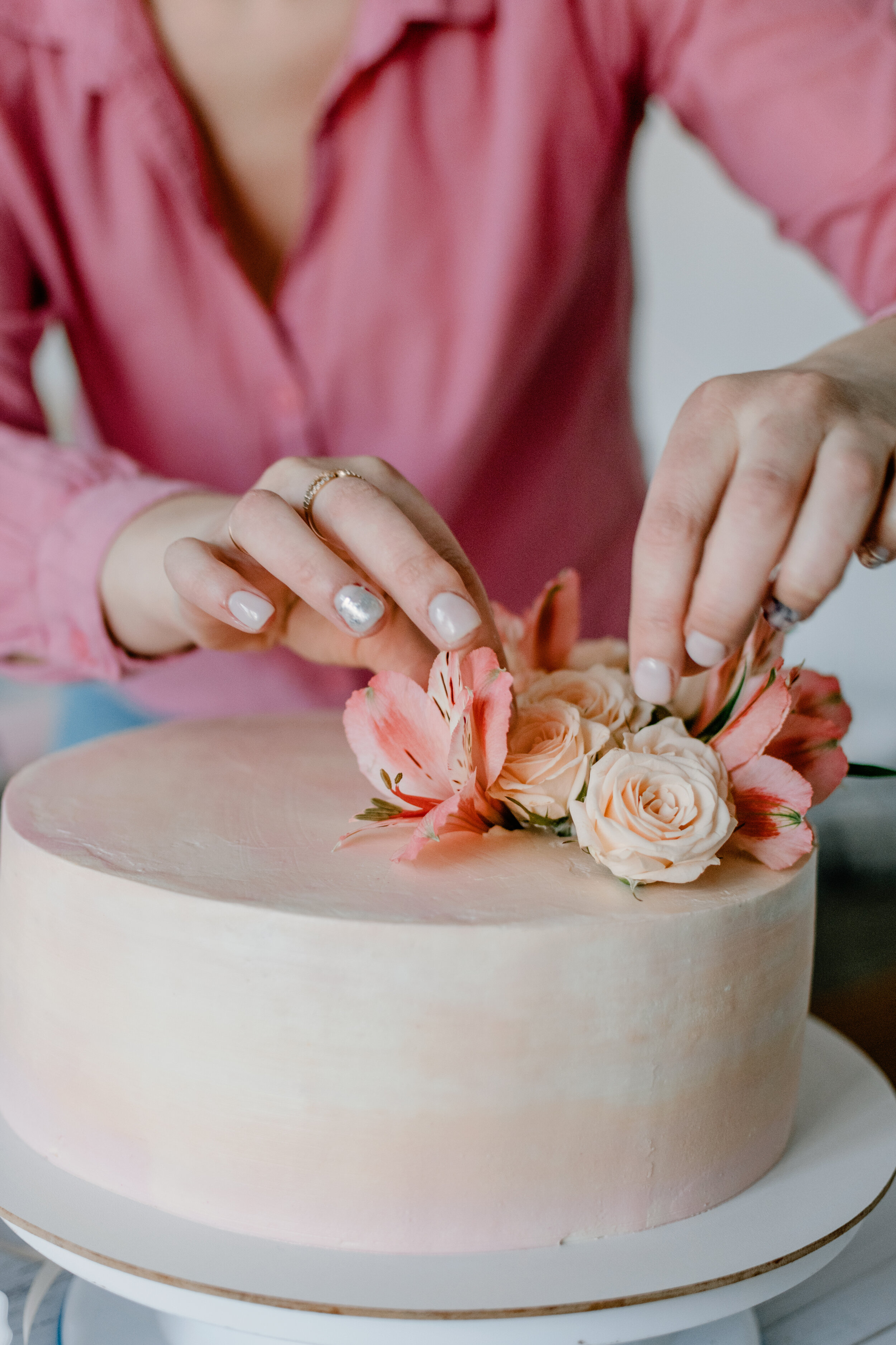 female-hand-decorating-pink-flower-wedding-birthda-V93AH4W.jpg