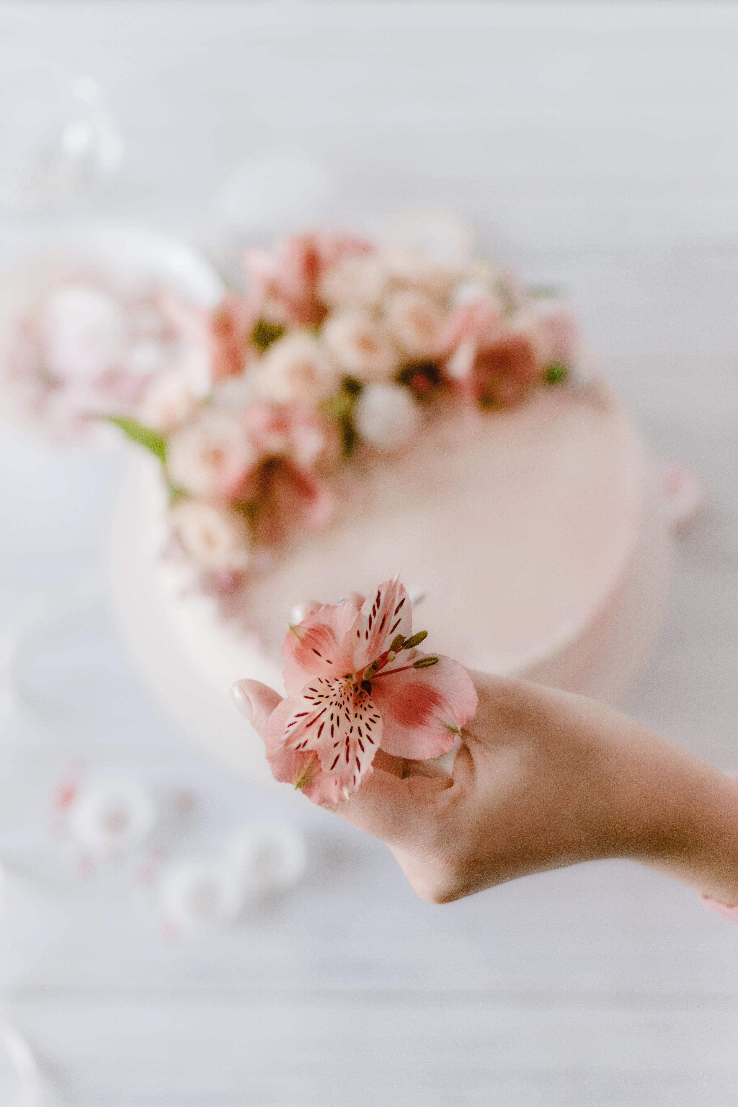 woman-hand-decorates-the-pink-wedding-birthday-cak-LYSEYUK.jpg