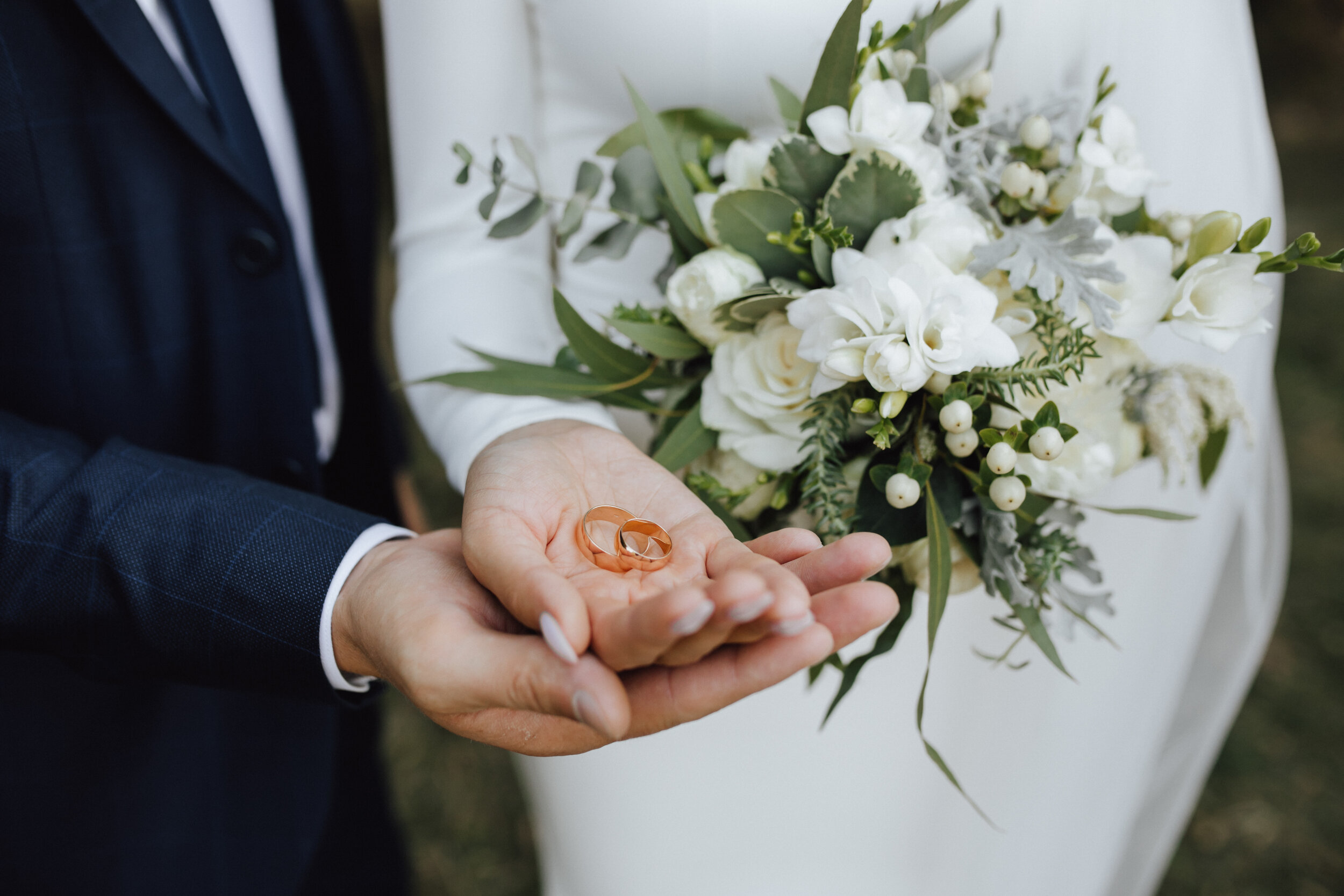 wedding-bands-hands-bride-groom-with-beautiful-wedding-bouquet-made-greenery-white-flowers.jpg