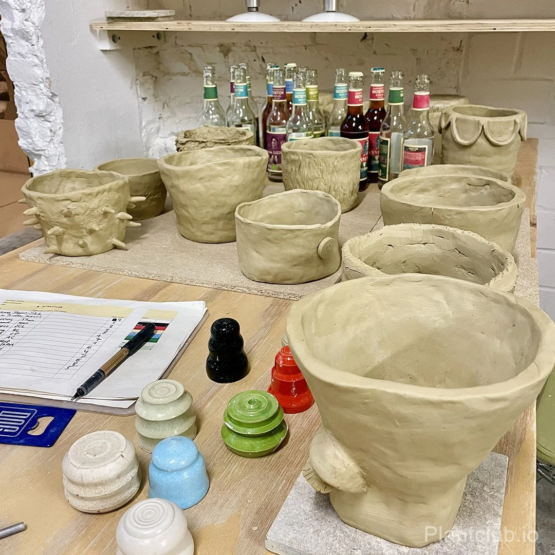  Freshly made pottery pieces awaiting their final glaze before housing vibrant greenery. 