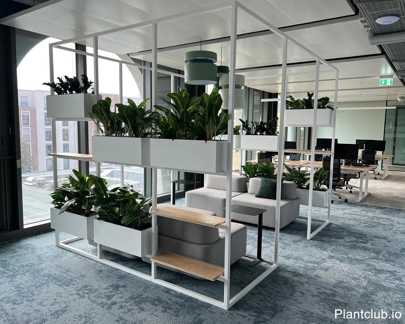 Large furnitures framing planters and couch in an office area