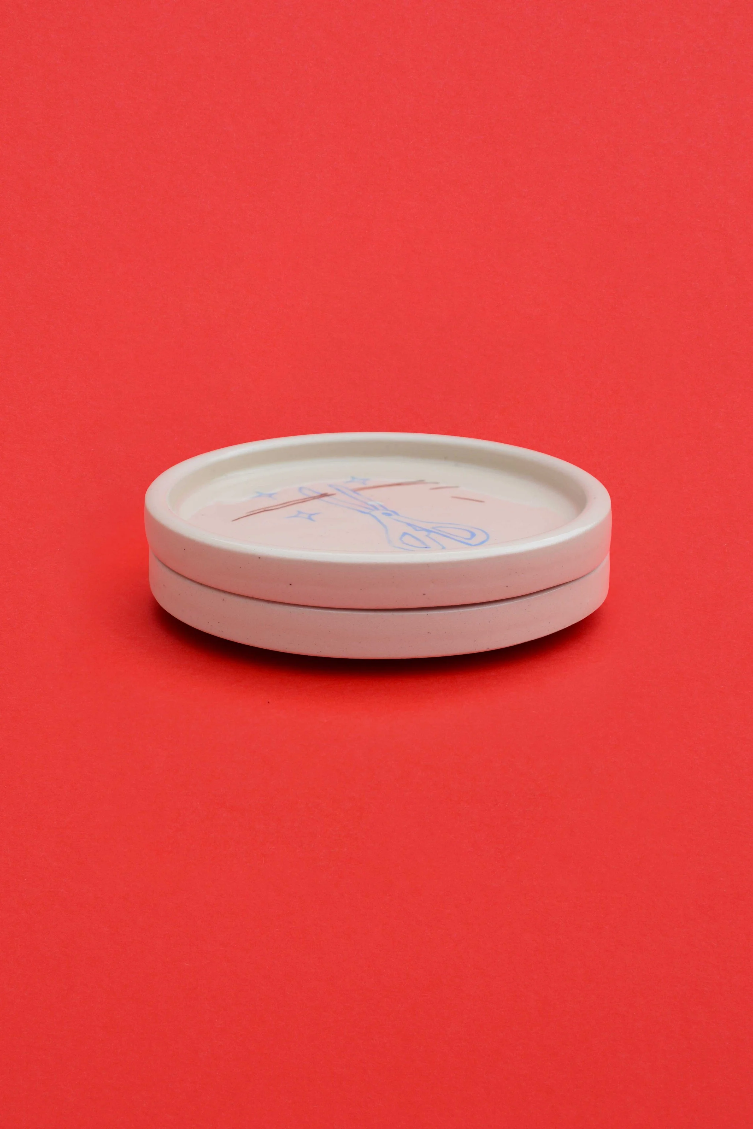 Just A Trim stoneware ceramic coaster set stack by artist, Isobel Hill. Two coasters are stacked upon one another.