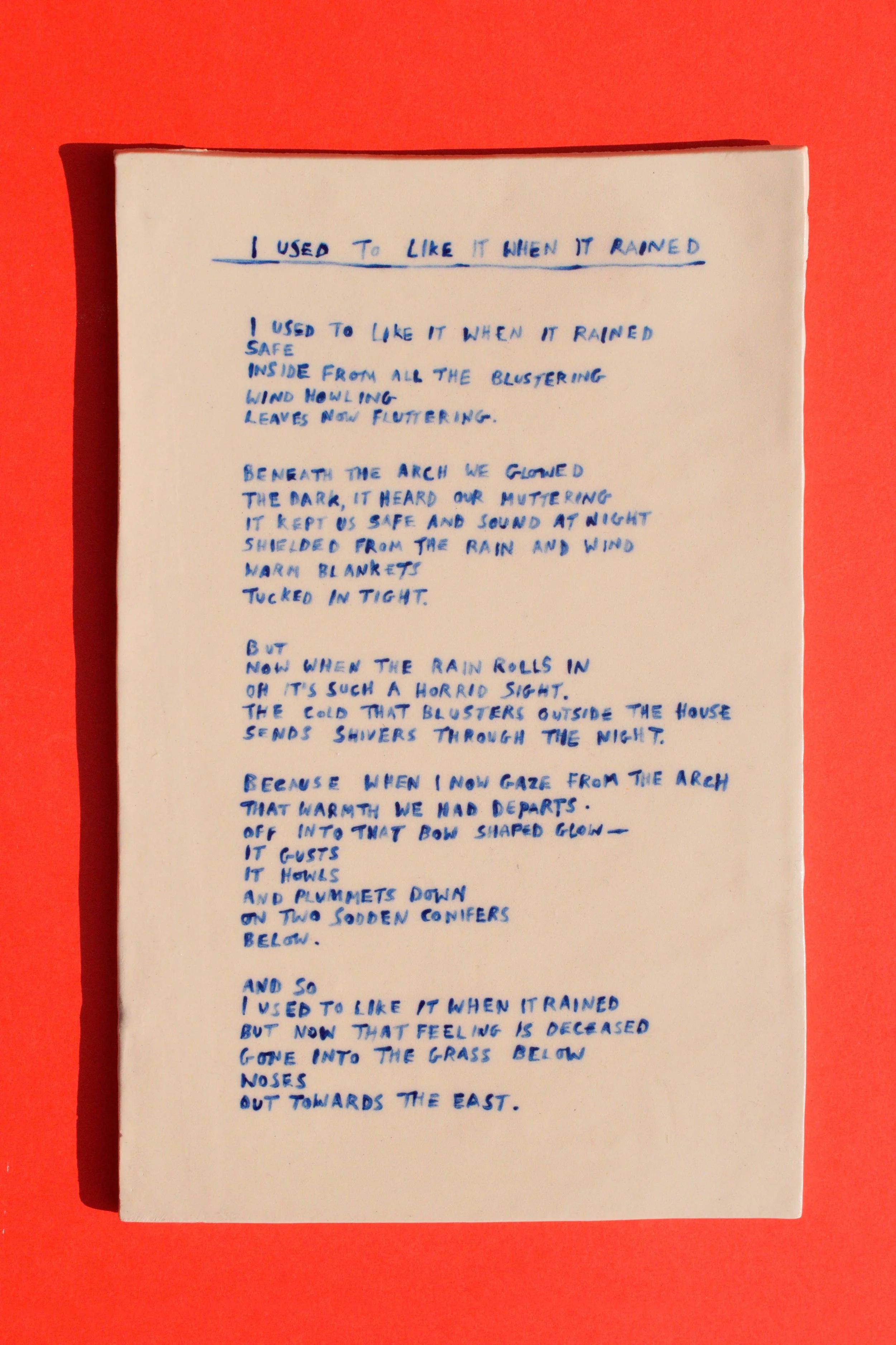 Objects portfolio of artist, Isobel Hill. 2025 Ceramic poetry tile, titled ‘I used to like it when it rained’. Blue underglaze handwriting on stoneware clear glazed tile.