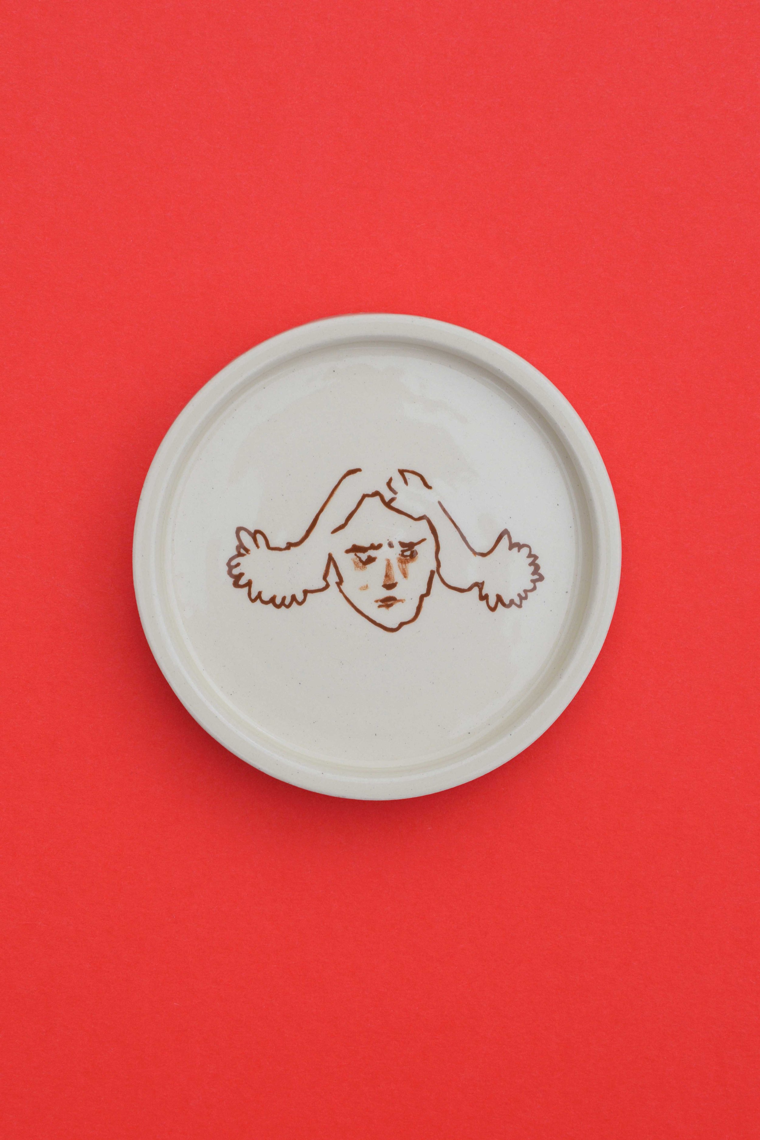 Stoneware ceramic coaster set by artist, Isobel Hill, featuring a person with brown hair looking downwards and irritated.