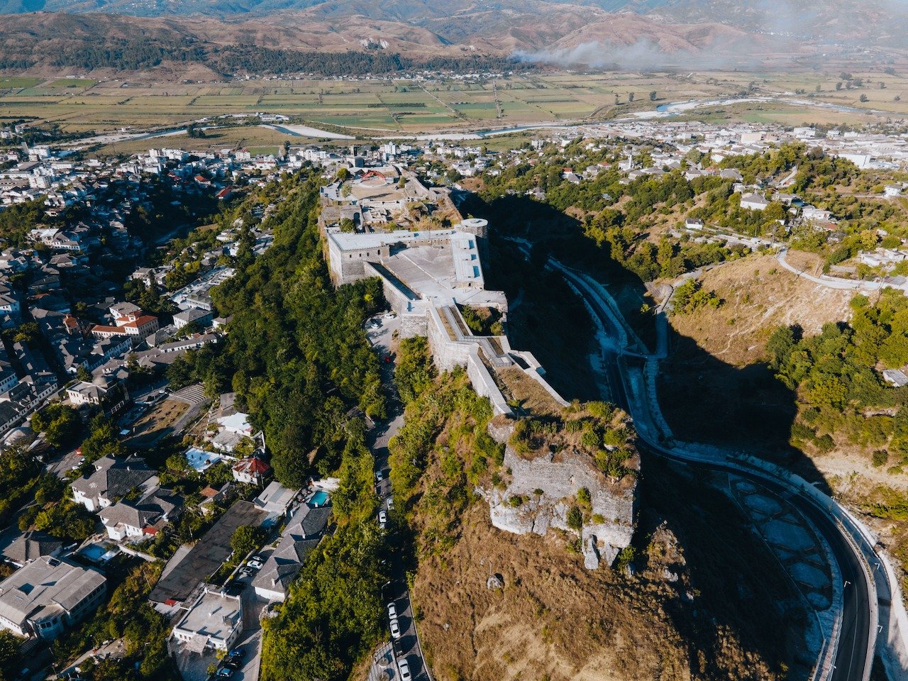 📍 Gjirokaster, Albania

Probably the best location you can have for a castle, I must say. Located on a plateau with steep slopes on nearly all sides. You can find this beauty at Gjirokaster in Albania. We stopped here for just a few hours but would 