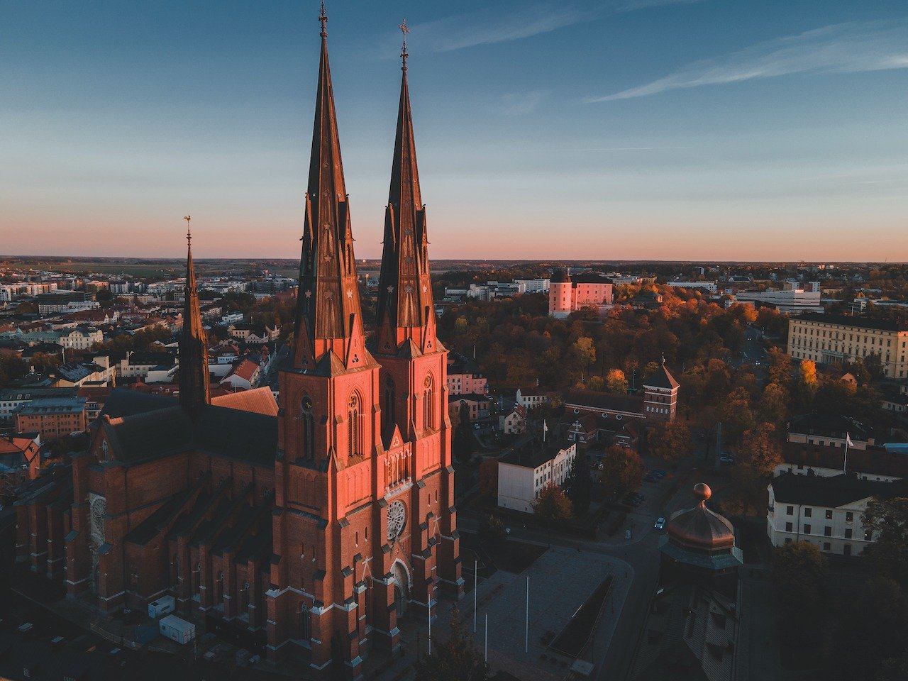 Soft autumn light wrapping Uppsala Cathedral 🍂✨

From above, the twin spires rise calmly over the city as warm golden tones meet cool Nordic blues. A moment where history, season, and light align &mdash; reminding you why this skyline is one of Swed