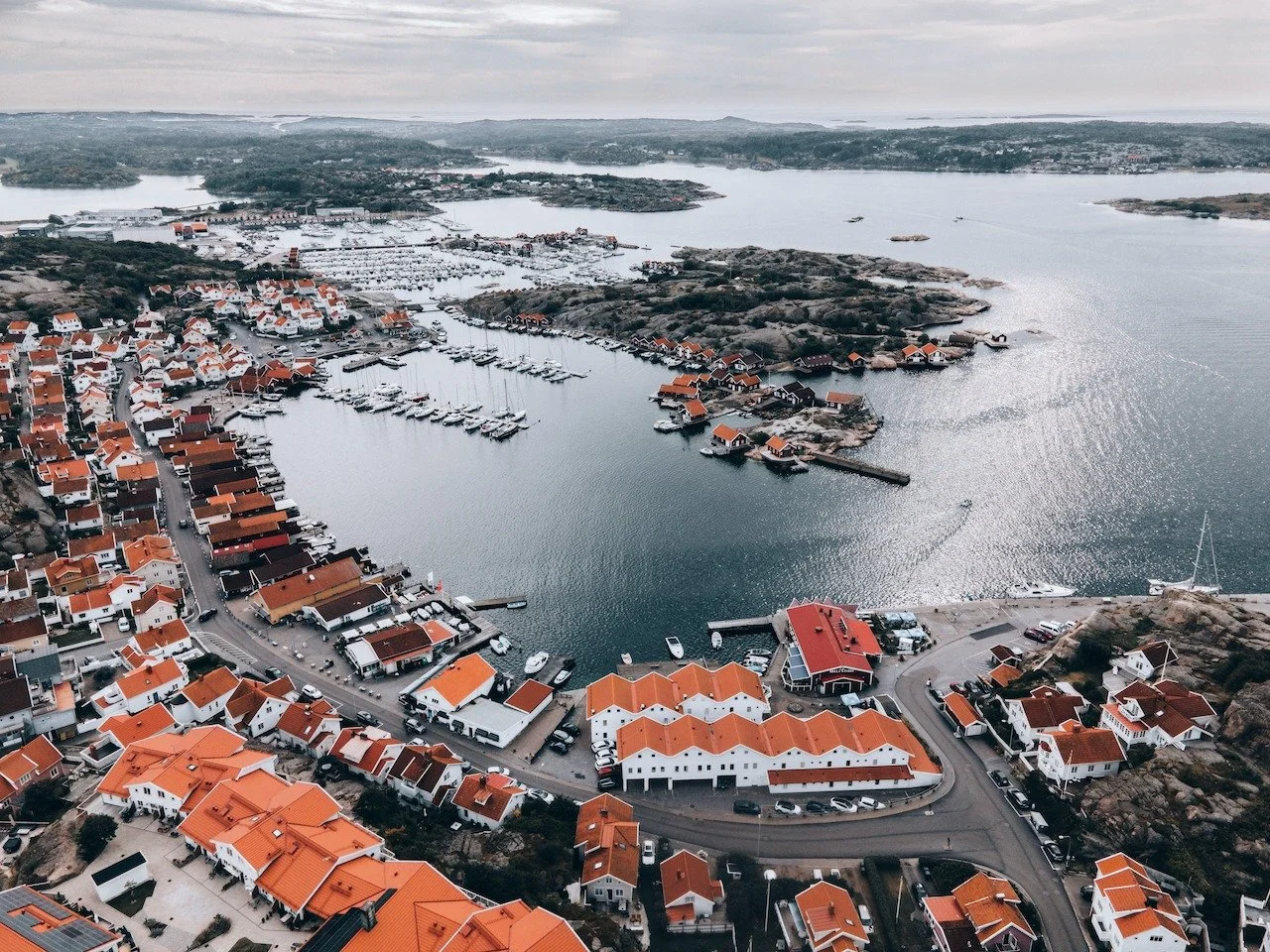 From above, the Bohusl&auml;n coast reveals its true character &mdash; scattered islands, calm waters, and red-roofed houses hugging the shoreline. Hunnebostrand developed as a fishing and stone-cutting village, with its granite once exported across 