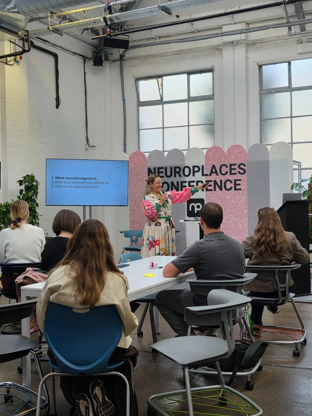 Photo of Ettie, a white woman presenting a talk at Neuroplaces conference about Neurodivergence