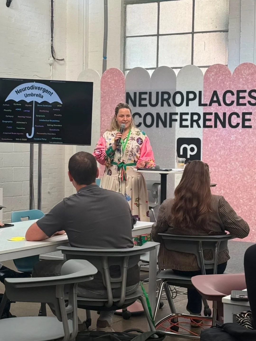 Photo of Ettie, a white woman presenting a talk at Neuroplaces conference about Neurodivergence