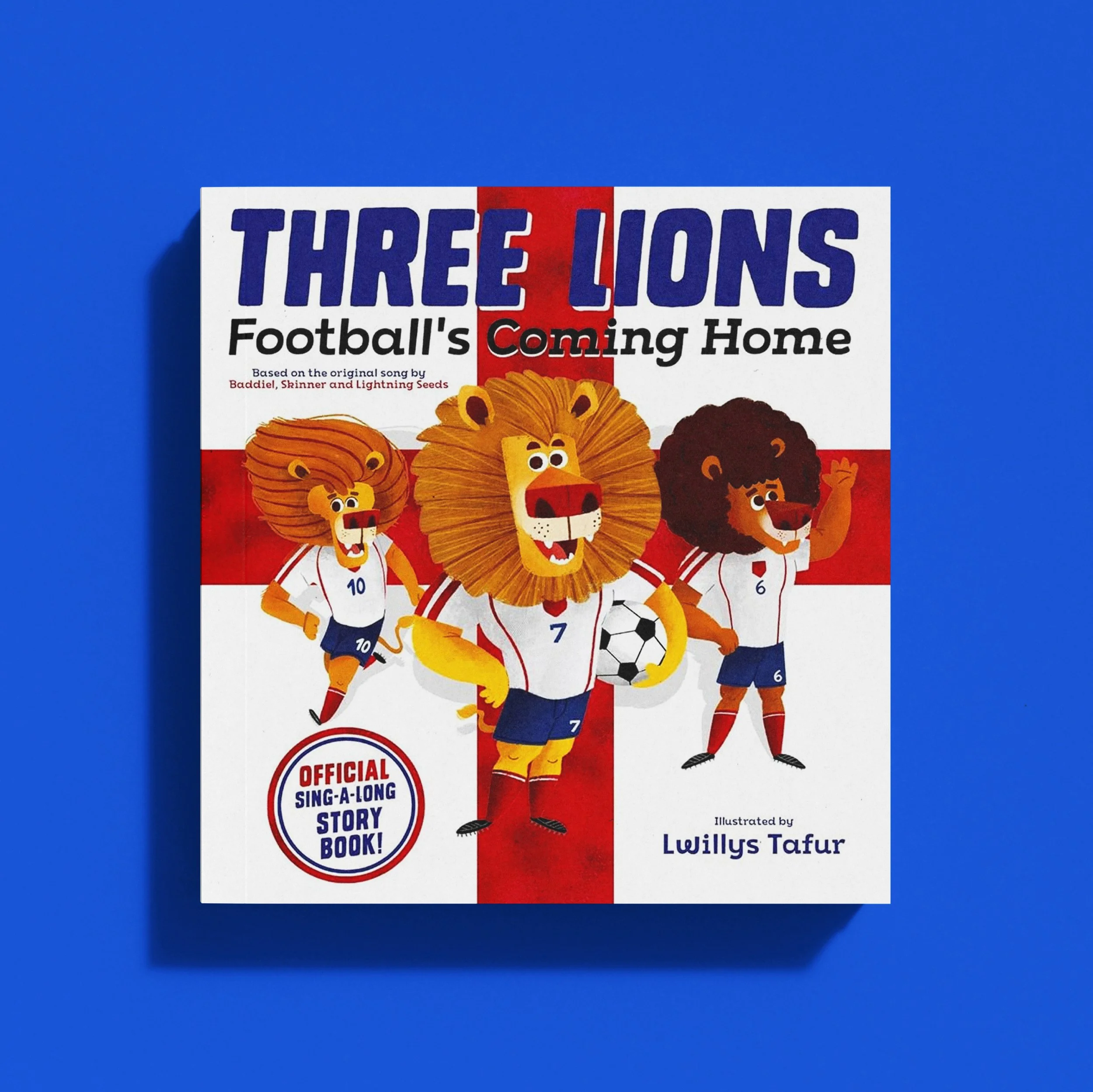 Children's book titled 'Three Lions Football's Coming Home' featuring cartoon lions dressed in England football kits, with a red and white background and a blue surface.
