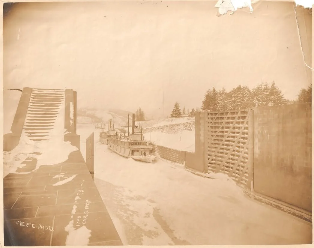 Sepia-toned photograph of two sternwheelers frozen inside of the Cascade Locks and Canal. Text on lower left says "pierce photo Jan 5 1909"
