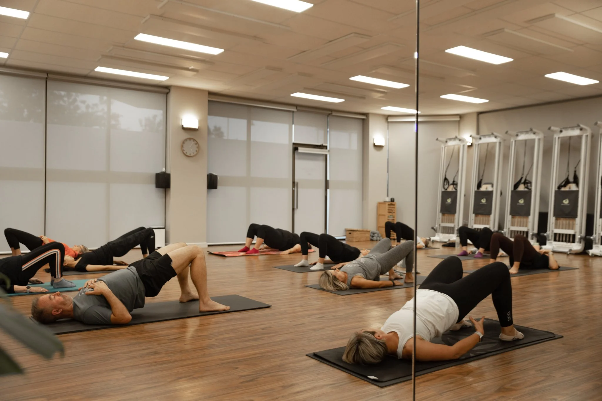 Group practising Mat Pilates in the Studio Sukha movement room in Horsham