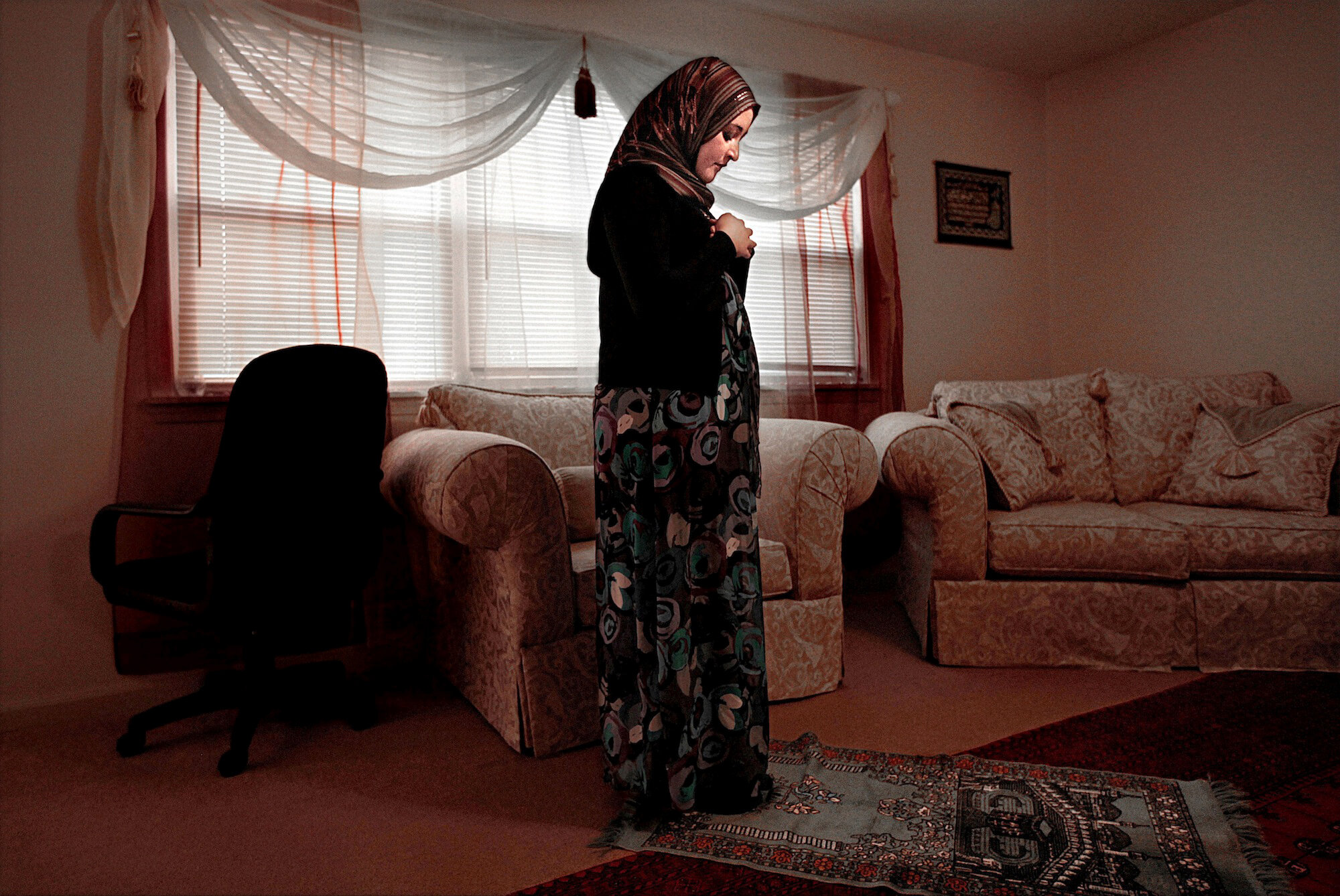   USA. St. Joseph, Missouri. 2010. Deeba Safi prays at her house. Deeba and her husband, Ahmad, have been working with other Muslim families to establish the first Mosque in St. Joseph but have faced a lot of resistance from the local non-Muslims. [U