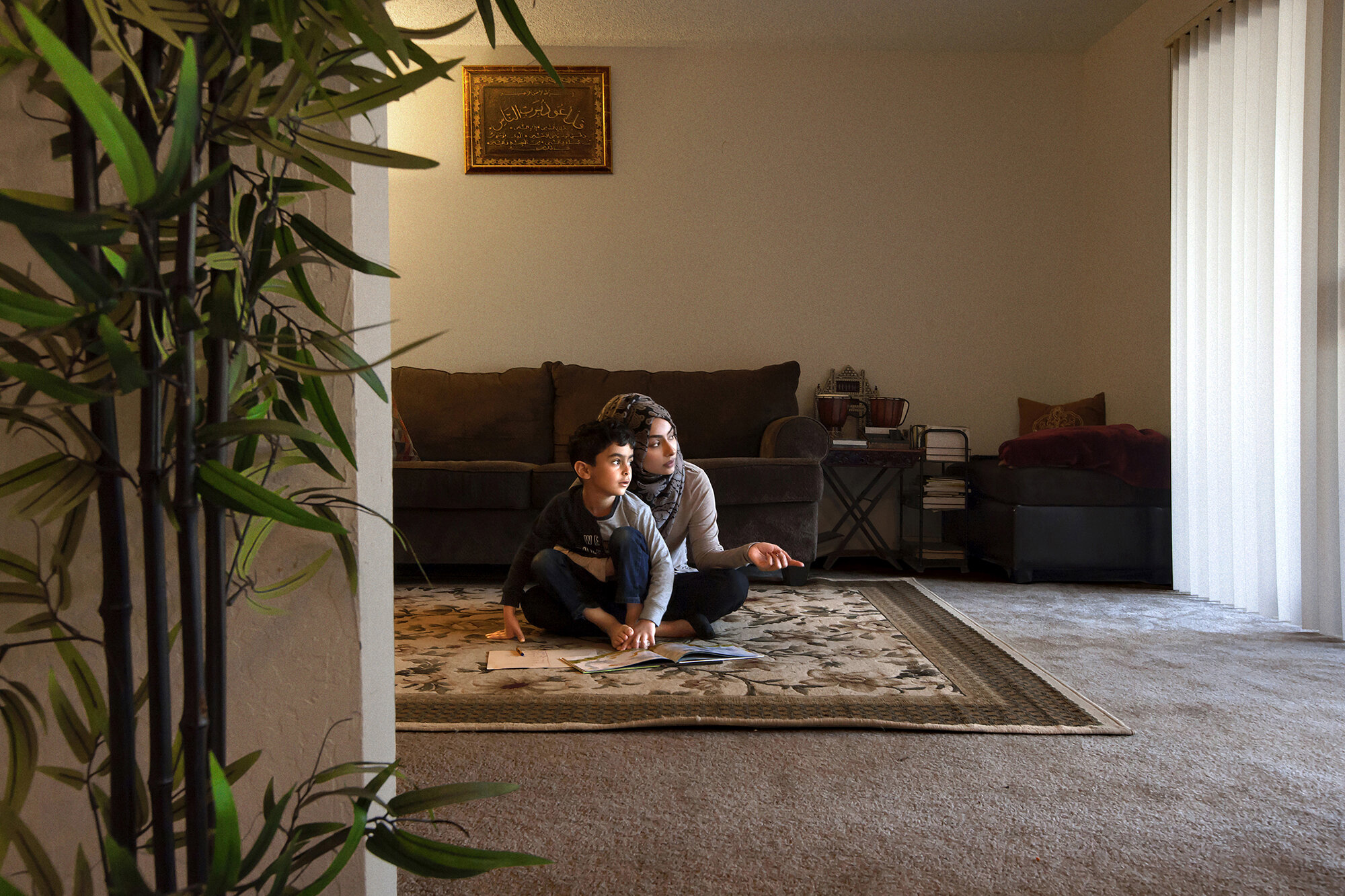   USA. Fremont, California. 2018. Jehan Hakim, 37, helps her 5-year-old son, Idrees Mubarez, to complete his school homework at their home. Jehan is a Community Advocate with the National Security and Civil Rights Program at the Asian Law Caucus (ALC